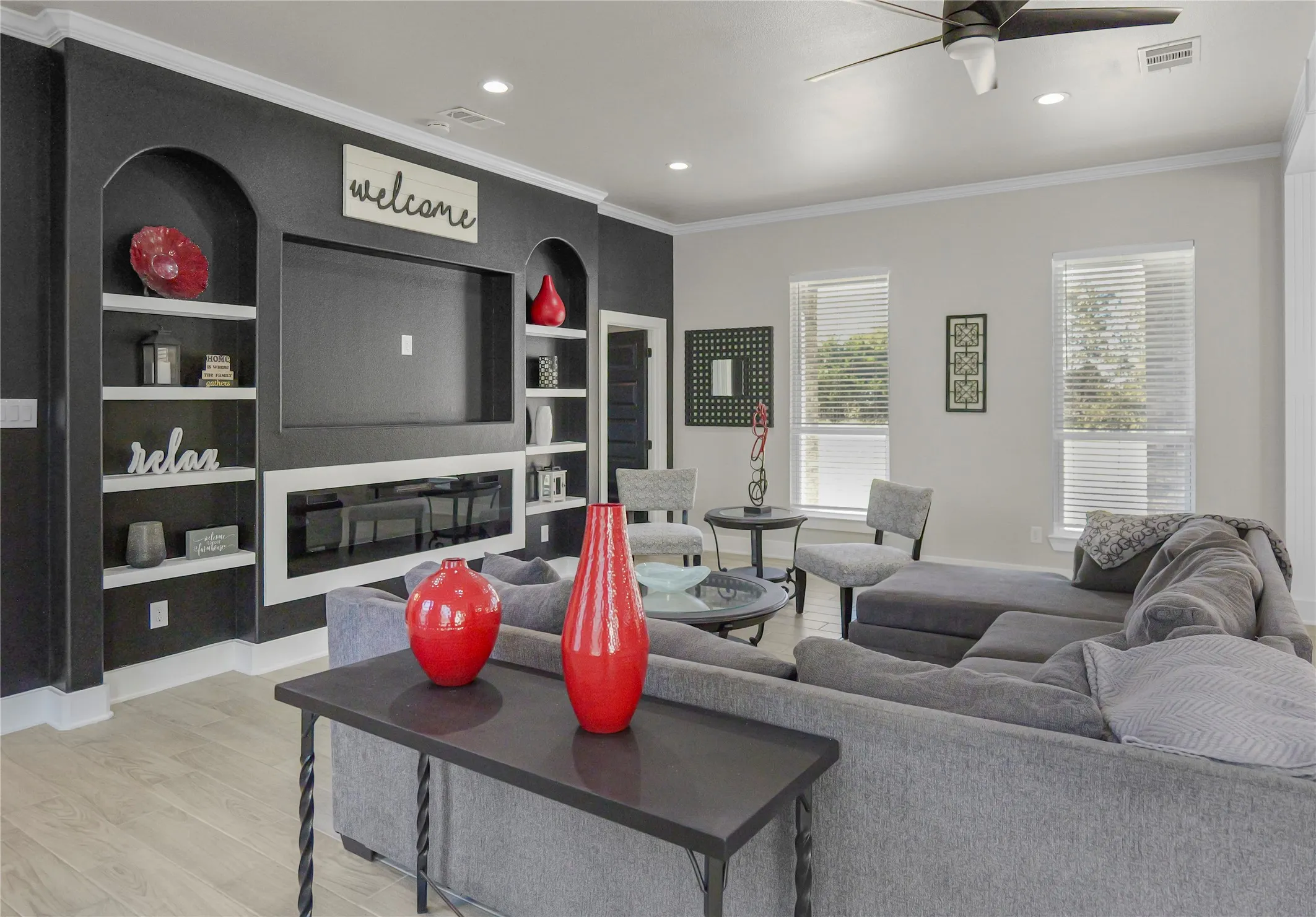 Living area with crown molding, light wood-style flooring, recessed lighting, built in features, and ceiling fan