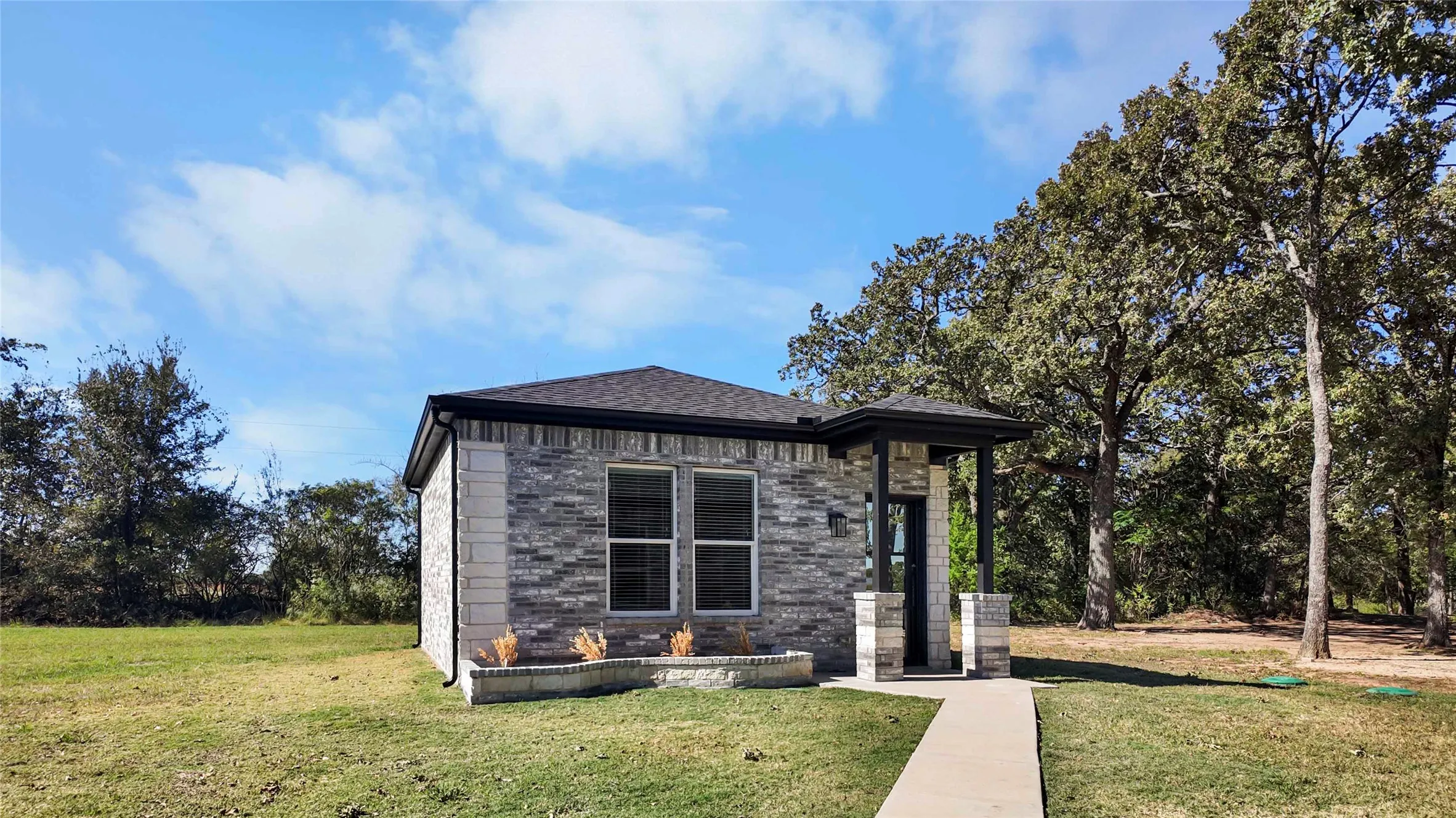 View of front of house with a front lawn and roof with shingles