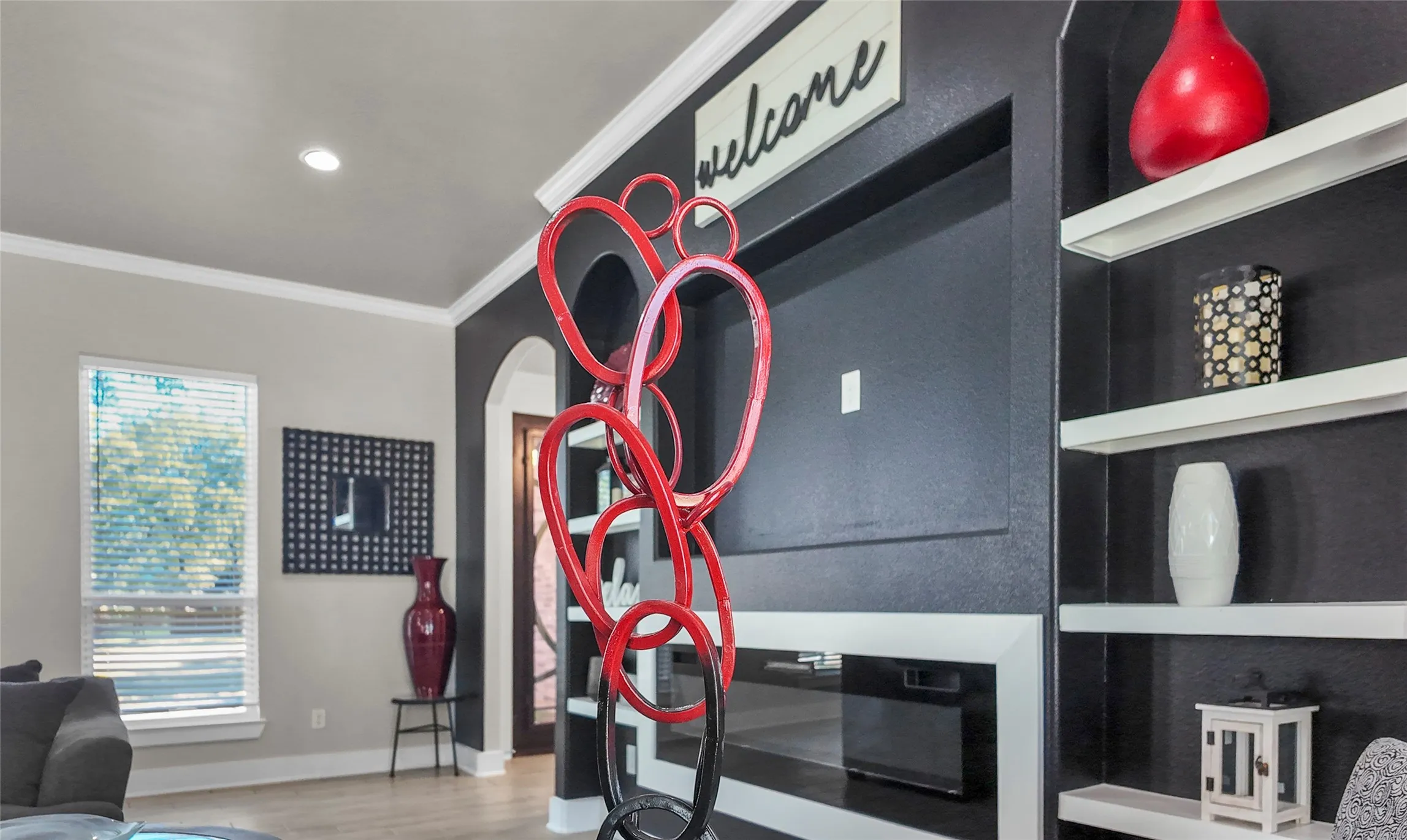 Detailed view of ornamental molding, wood finished floors, arched walkways, and recessed lighting