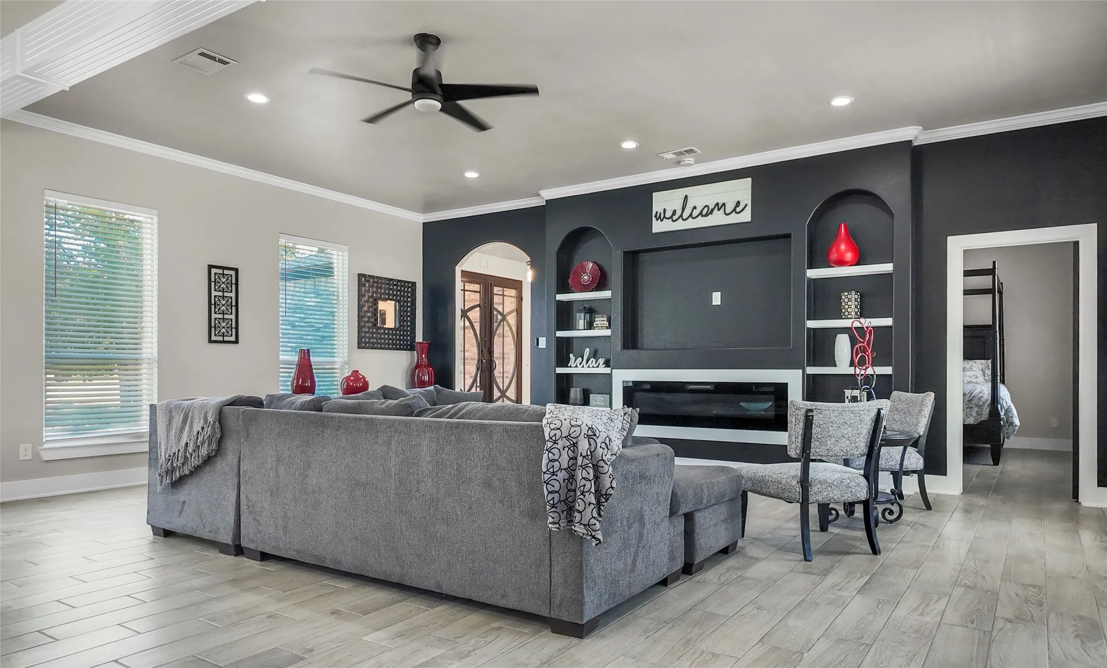Living room featuring ornamental molding, a ceiling fan, light wood-style flooring, and recessed lighting