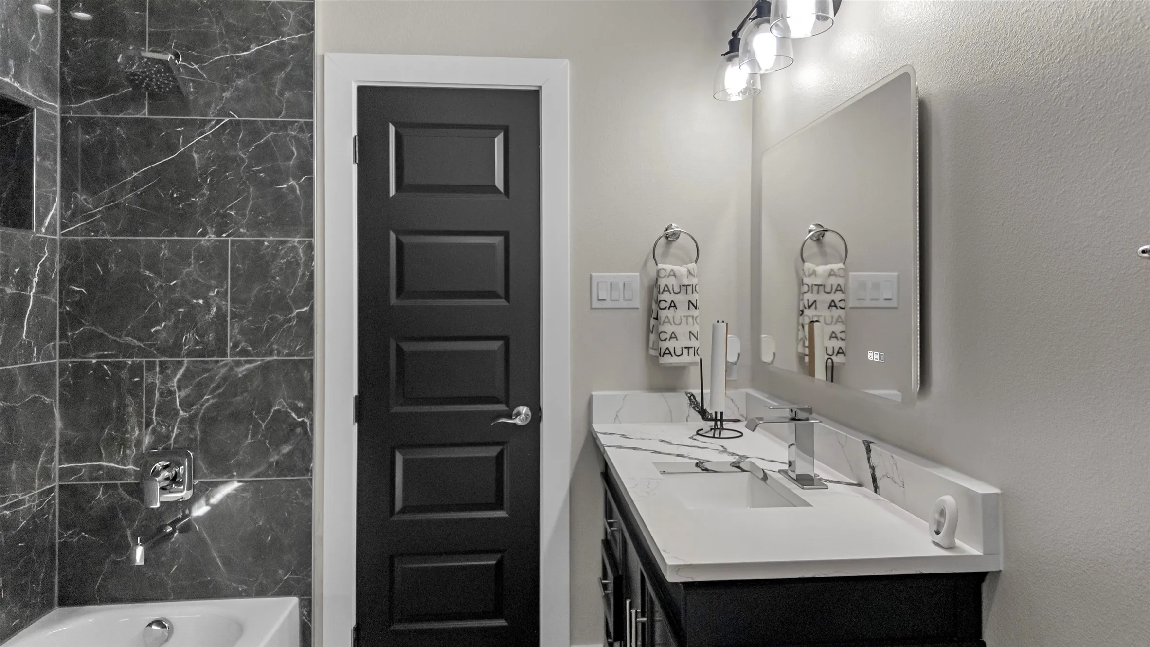 Bathroom featuring vanity, shower / bathtub combination, and a textured wall