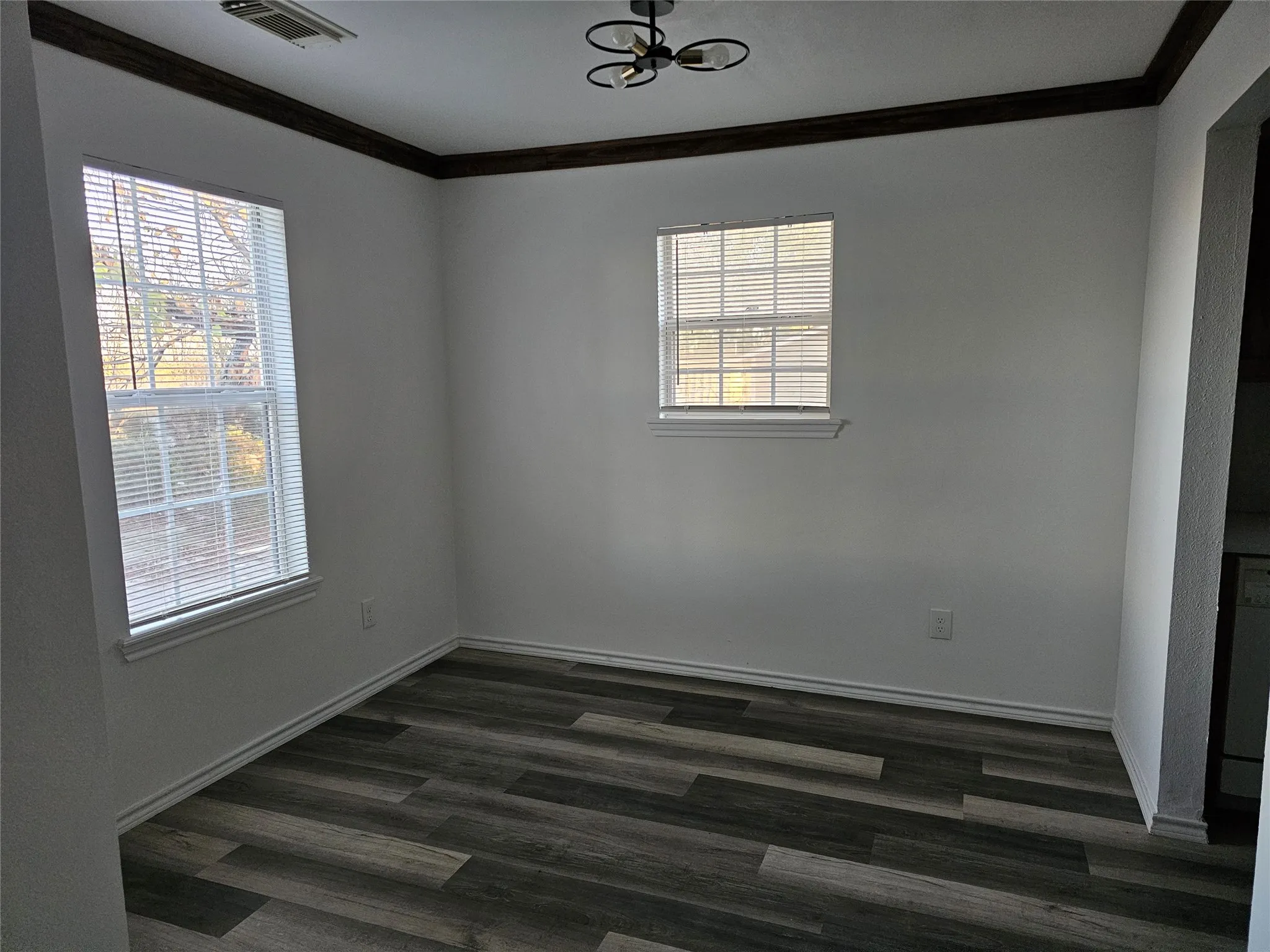 Dining room featuring ornamental molding and dark wood-type flooring