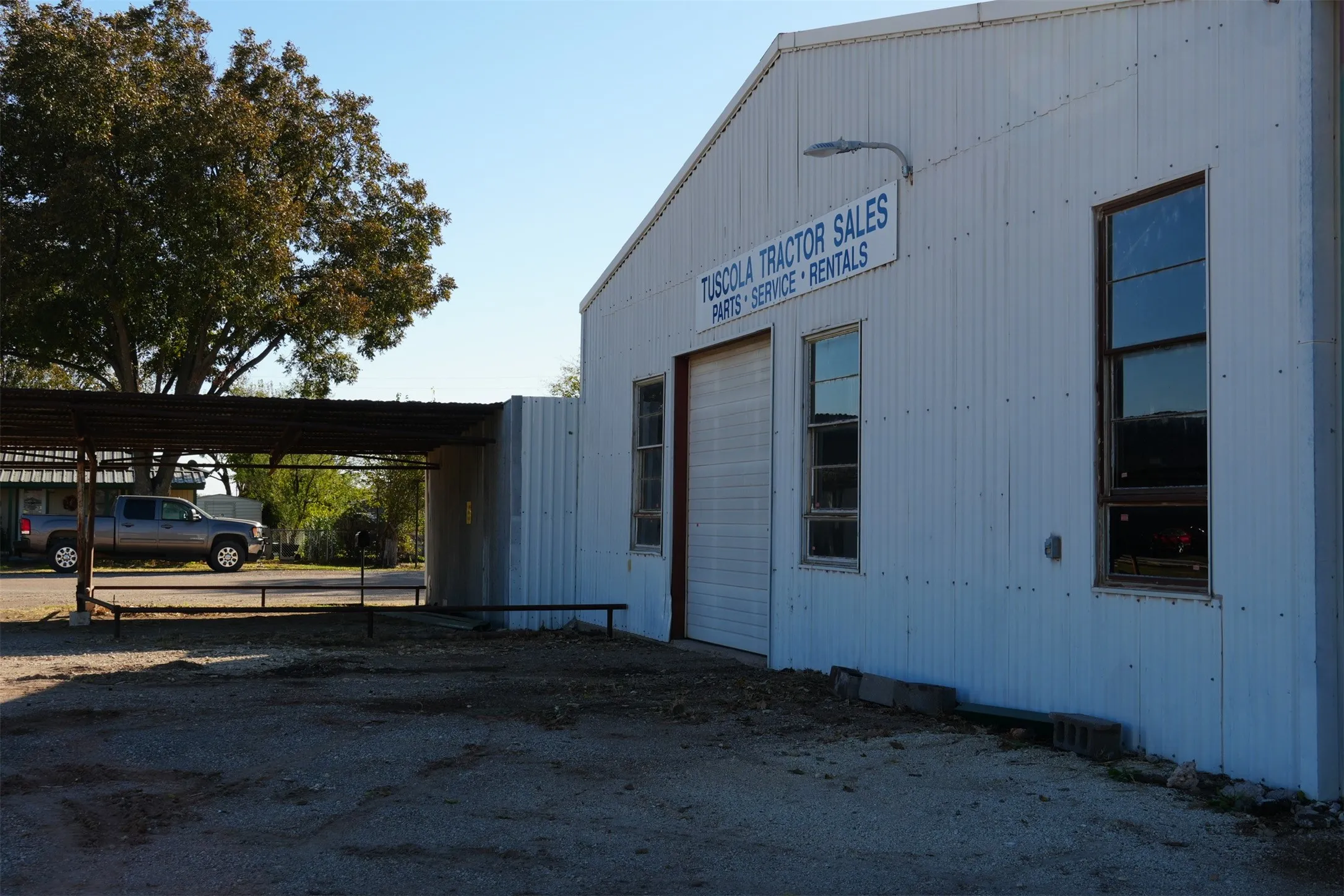 View of side of home with a carport and dirt driveway