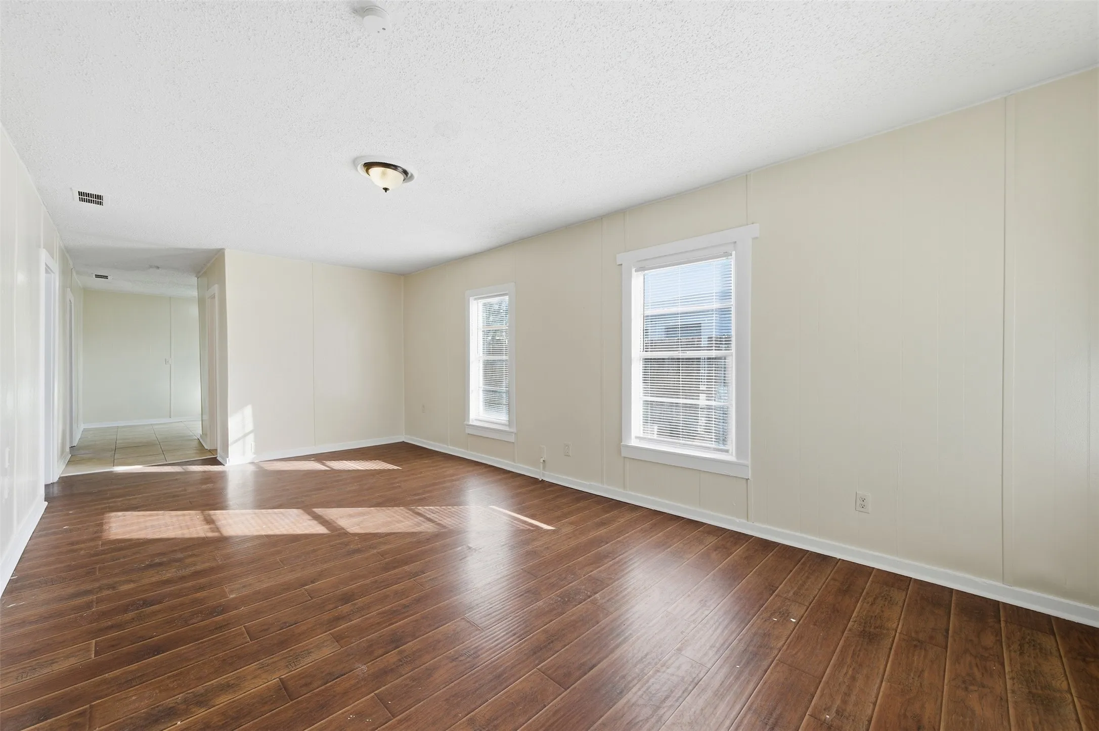 Spare room with a textured ceiling and dark wood-type flooring