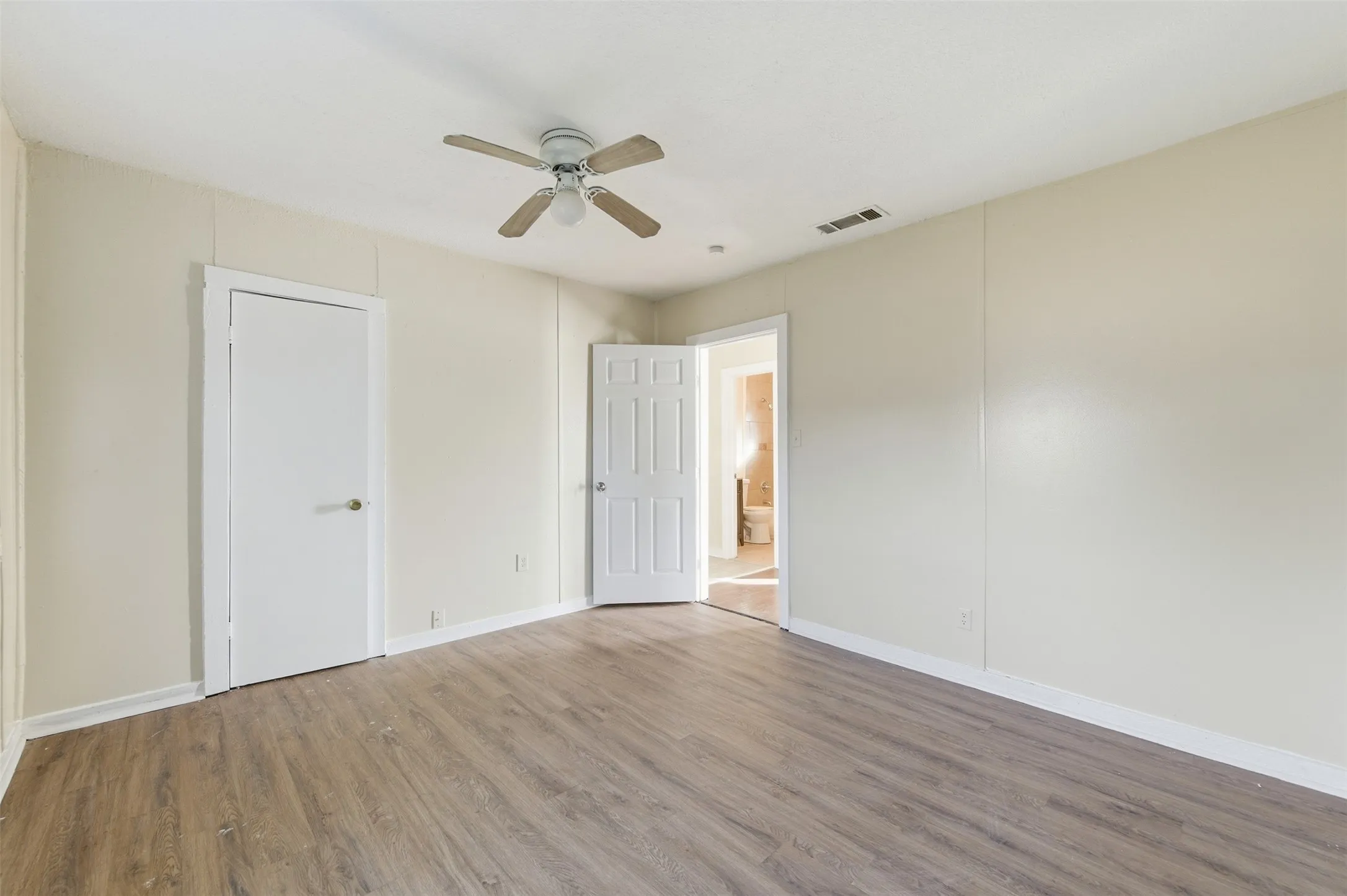 Unfurnished bedroom with wood finished floors and a ceiling fan