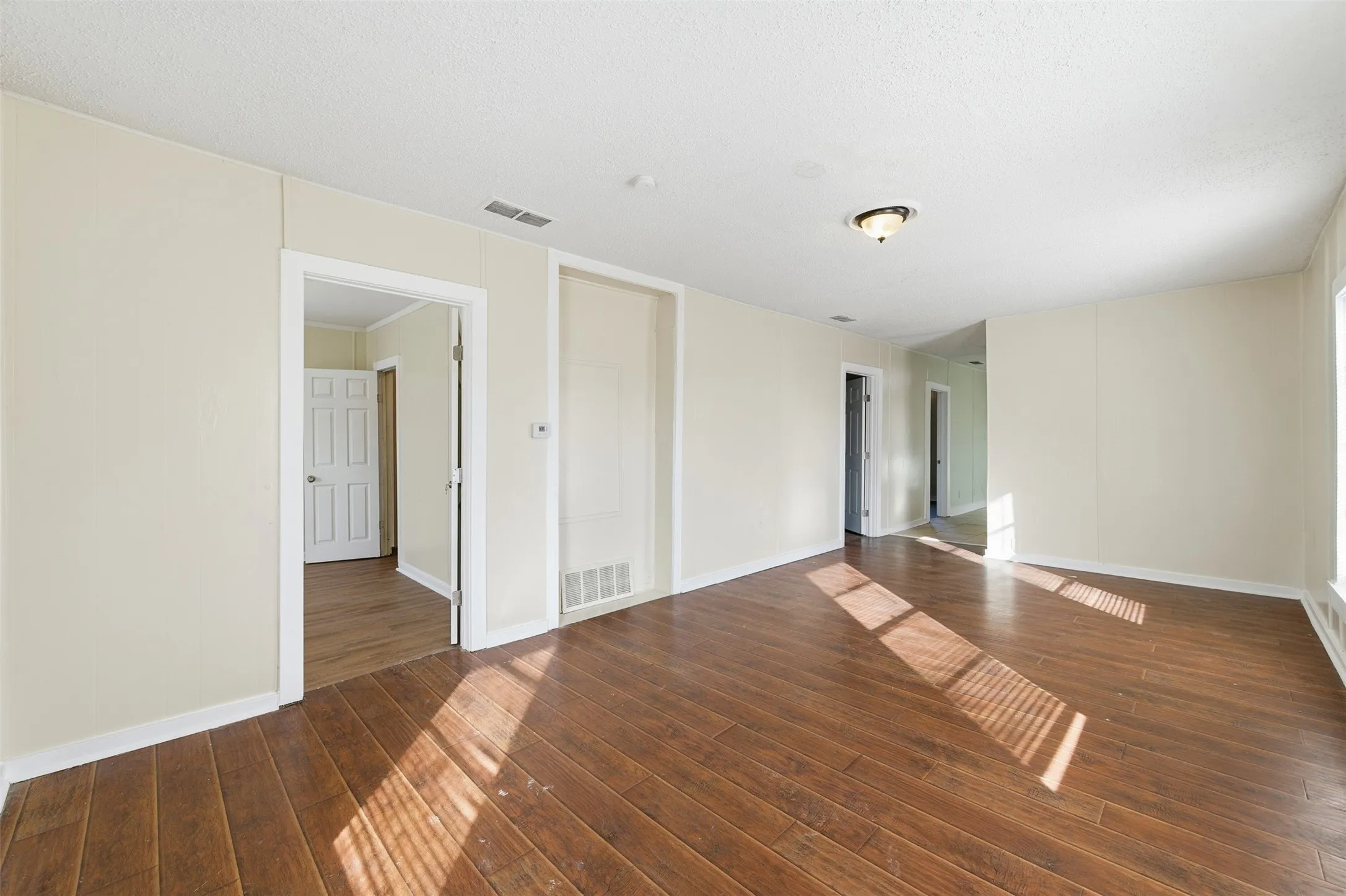 Spare room with dark wood finished floors and a textured ceiling