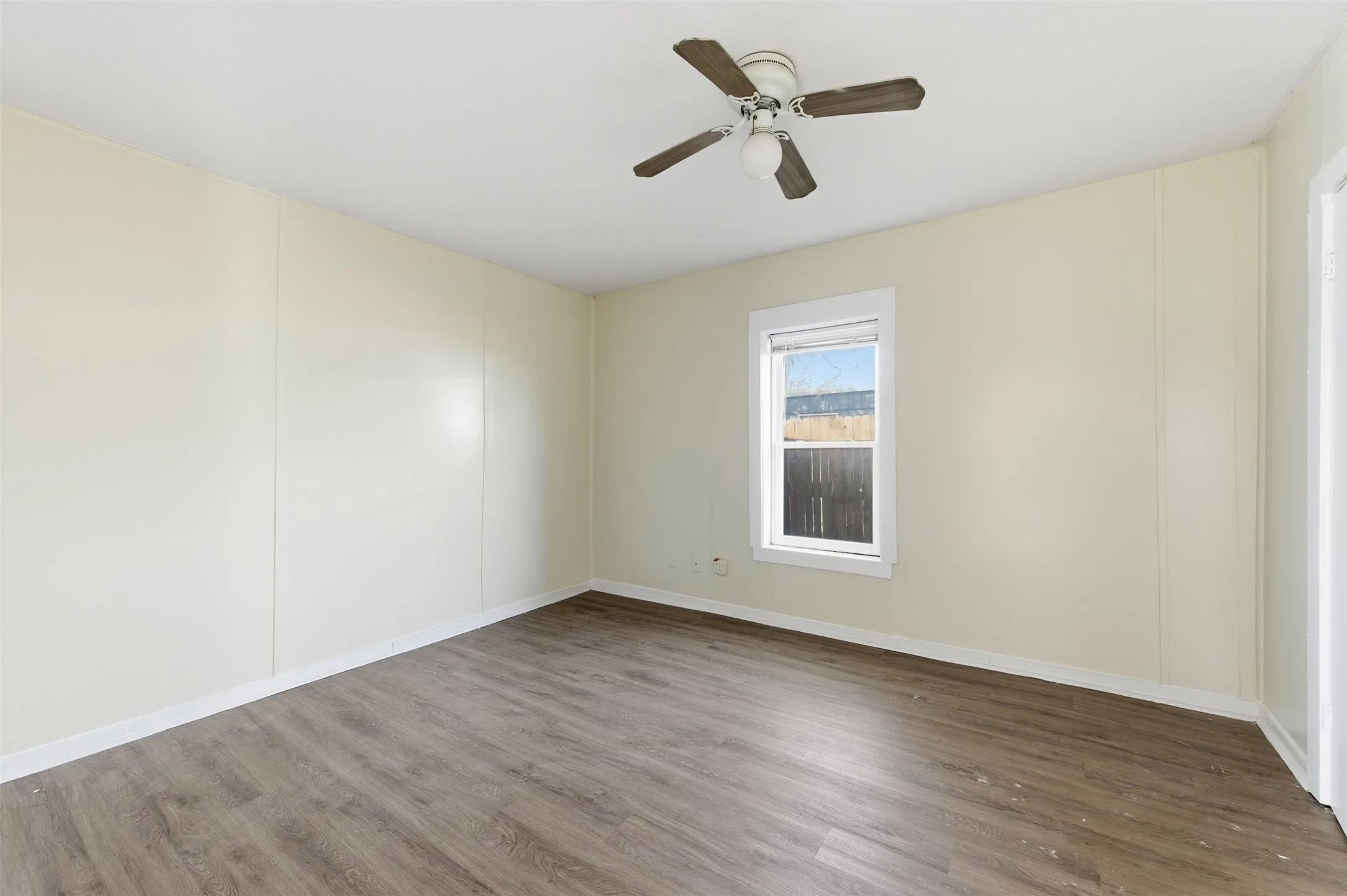 Spare room featuring dark wood-type flooring and ceiling fan