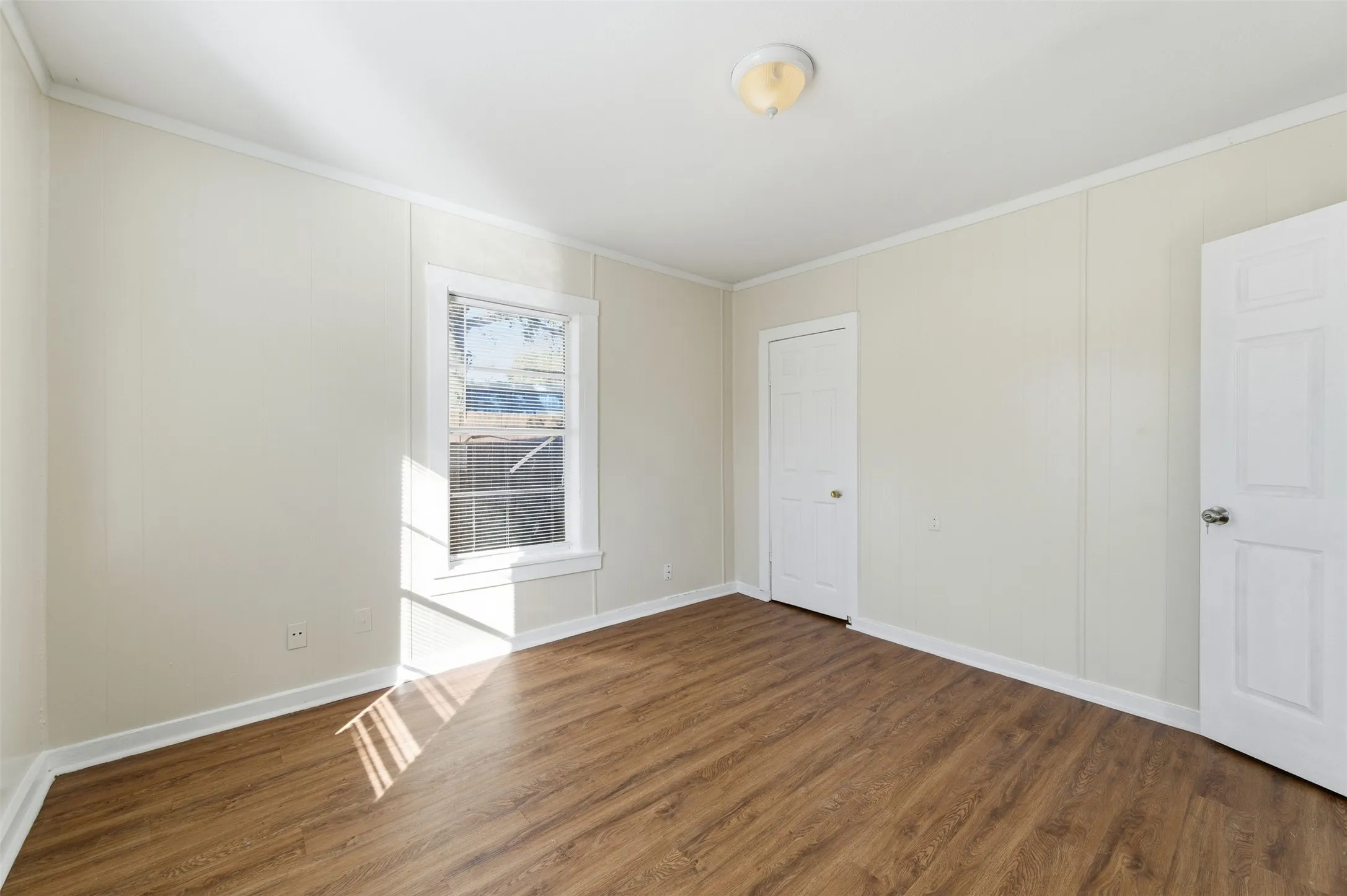 Unfurnished room featuring ornamental molding and wood finished floors