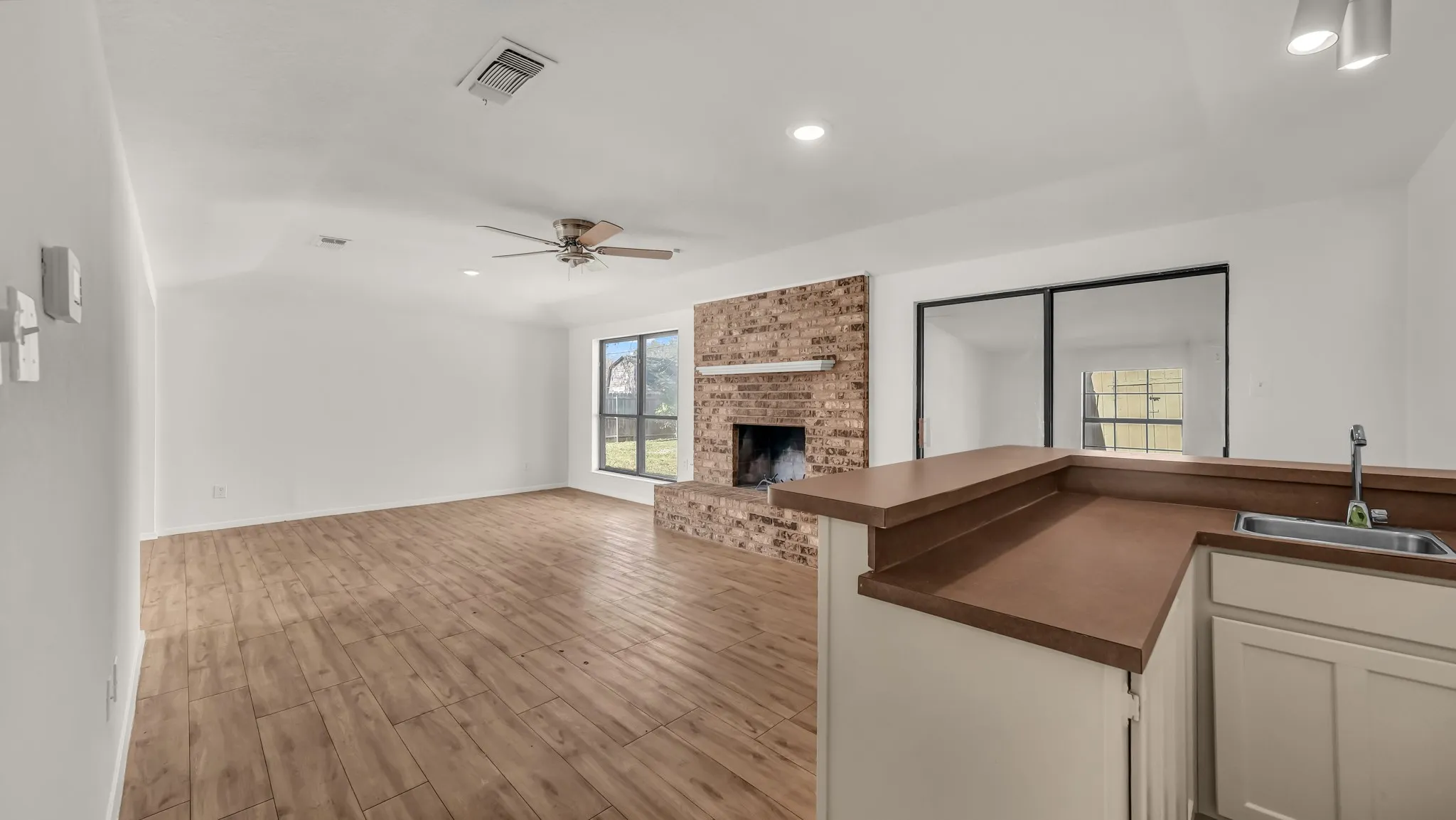 Kitchen featuring white cabinets, dark countertops, light wood-type flooring, recessed lighting, and a ceiling fan