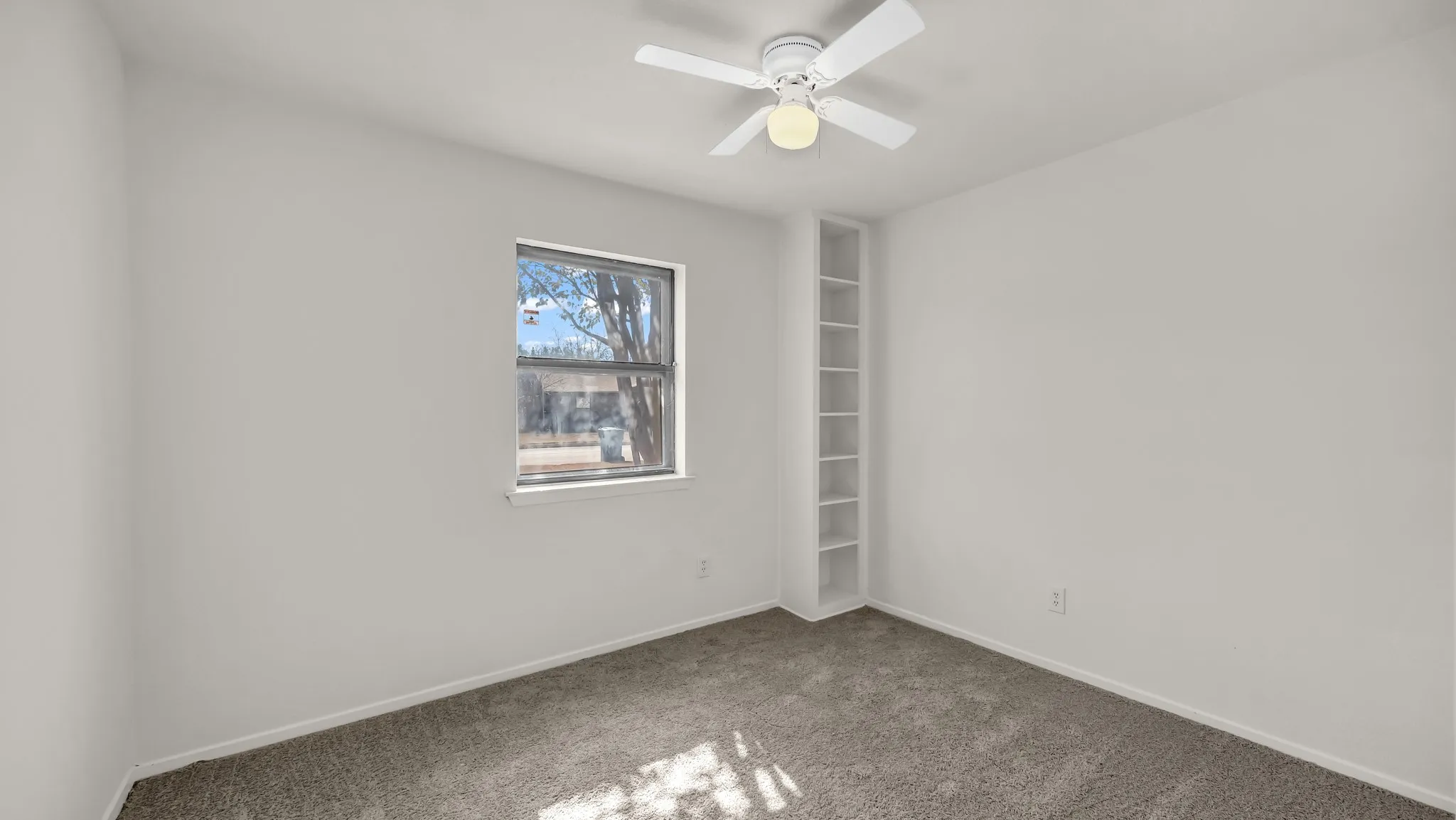 Empty room with carpet flooring and ceiling fan