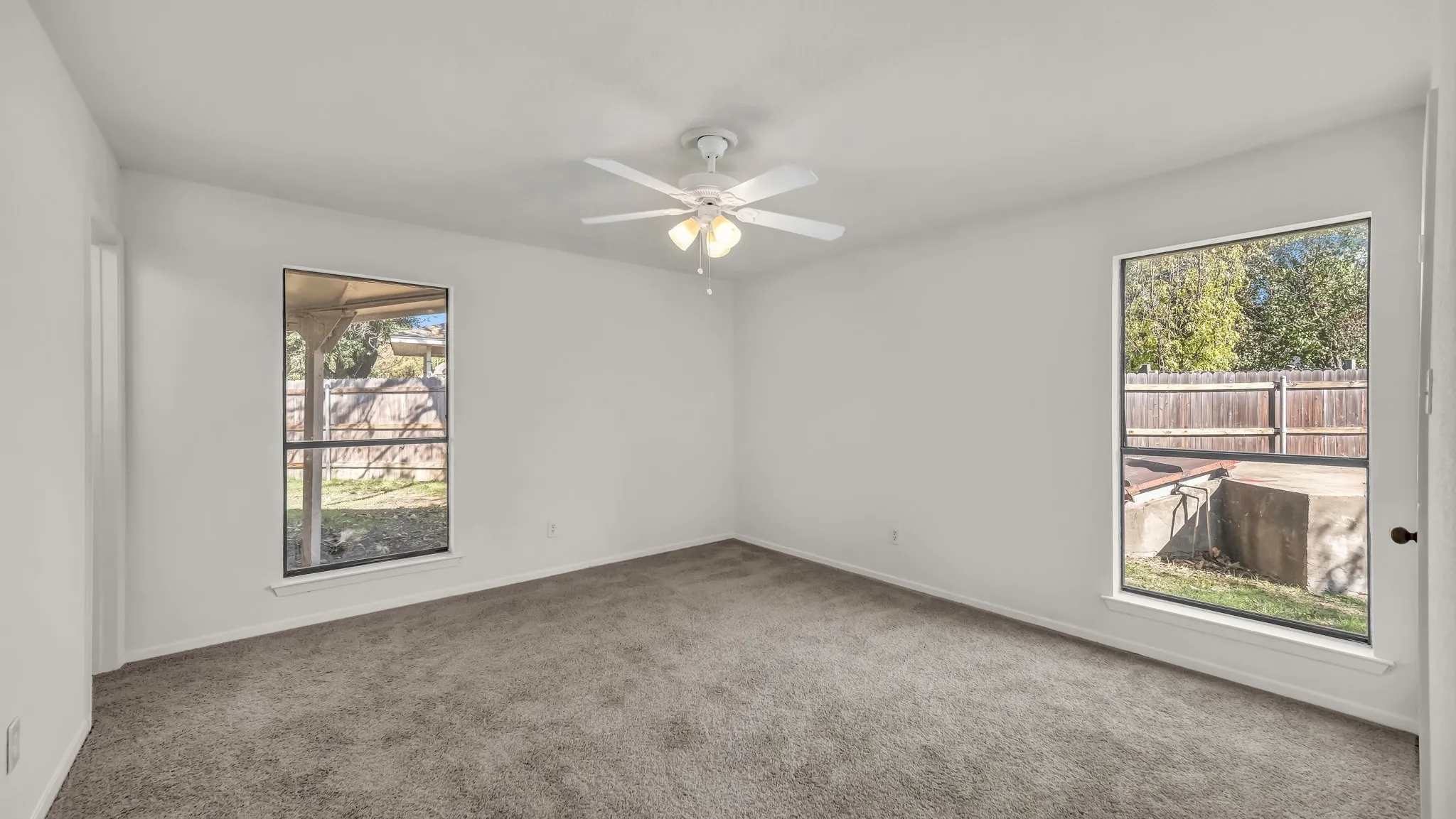 Spare room featuring carpet and a ceiling fan