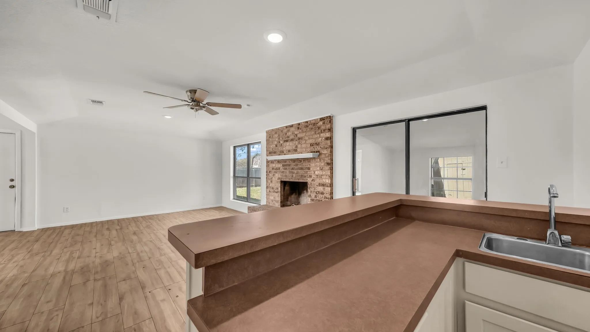 Unfurnished living room featuring light wood-style flooring, a fireplace, recessed lighting, and a ceiling fan