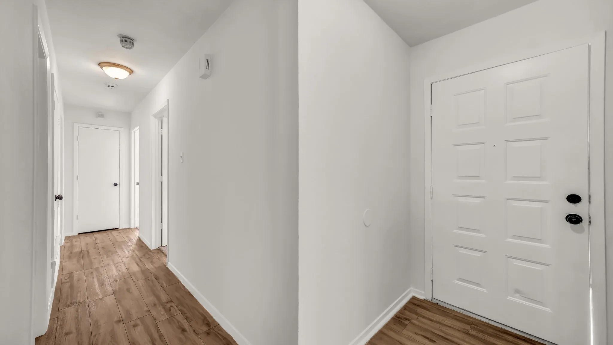 Hallway featuring wood finished floors and baseboards