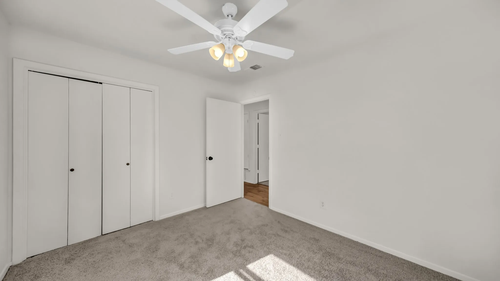 Unfurnished bedroom featuring carpet floors, a closet, and ceiling fan