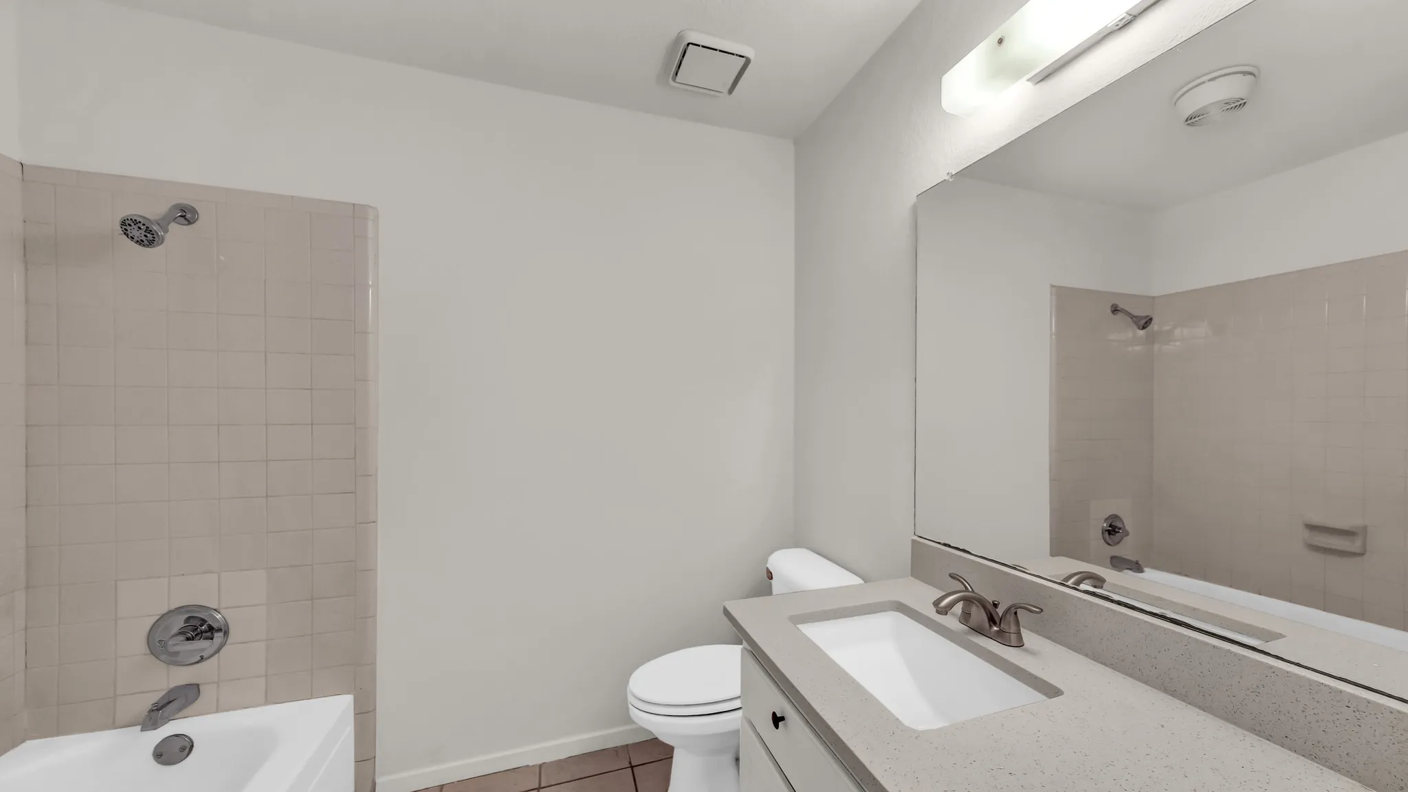 Full bath featuring vanity, washtub / shower combination, and light tile patterned floors