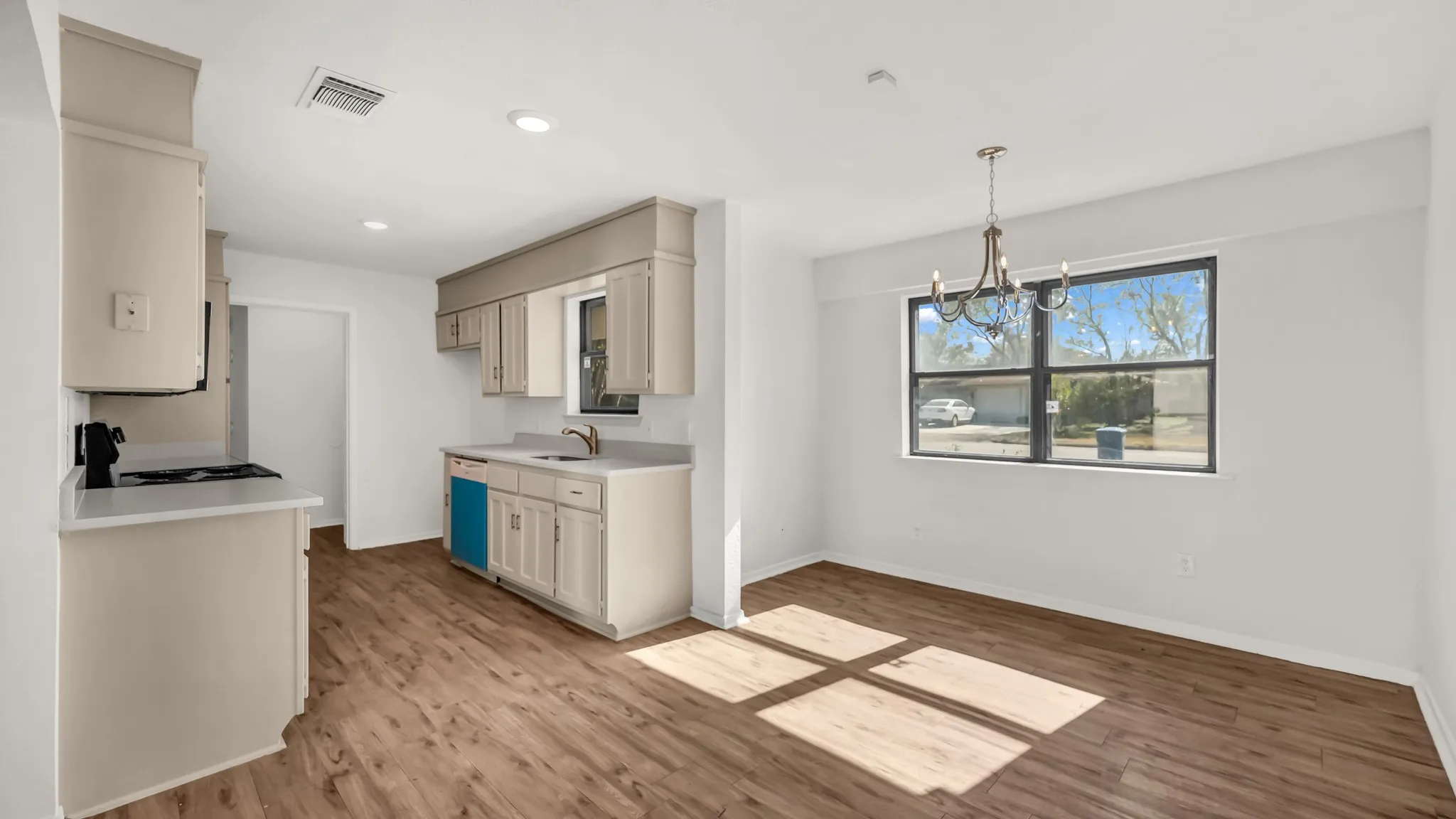 Kitchen with light countertops, a chandelier, recessed lighting, black electric range oven, and light wood-type flooring
