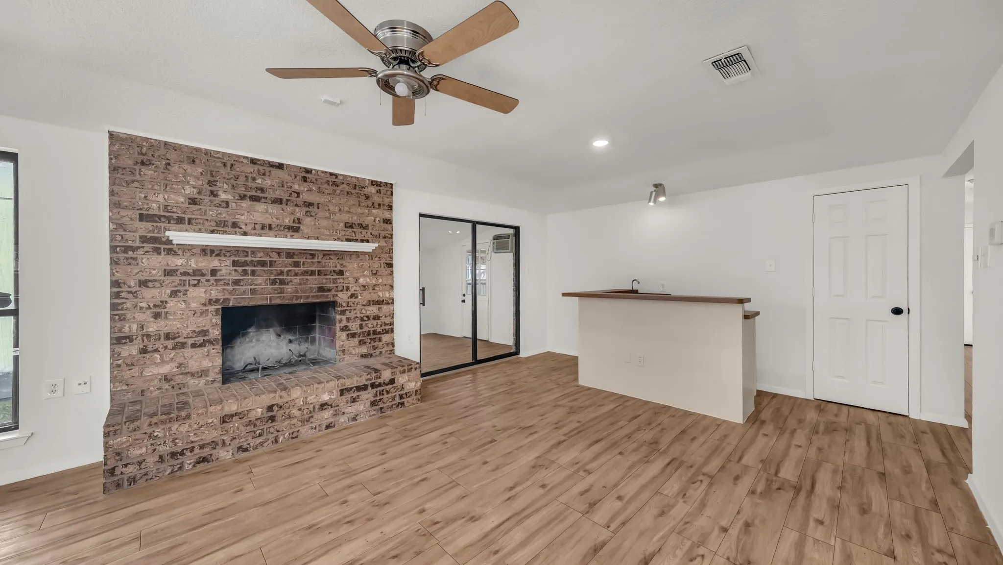 Unfurnished living room featuring light wood-style floors, a fireplace, recessed lighting, and a ceiling fan