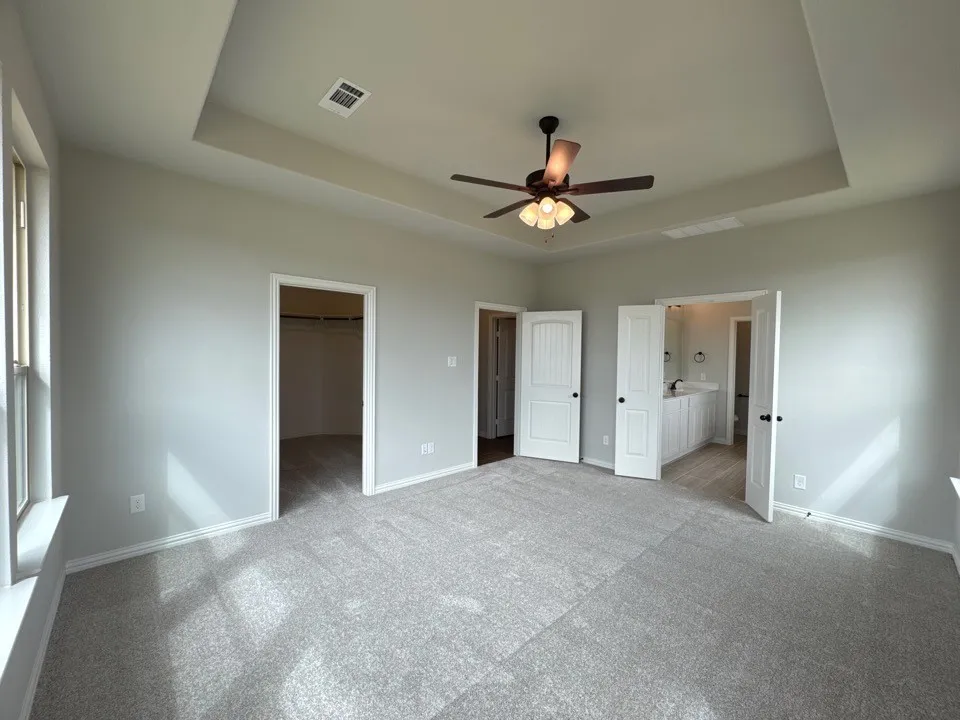 Unfurnished living room with a fireplace, ceiling fan, wood finish floors, and suspended lighting