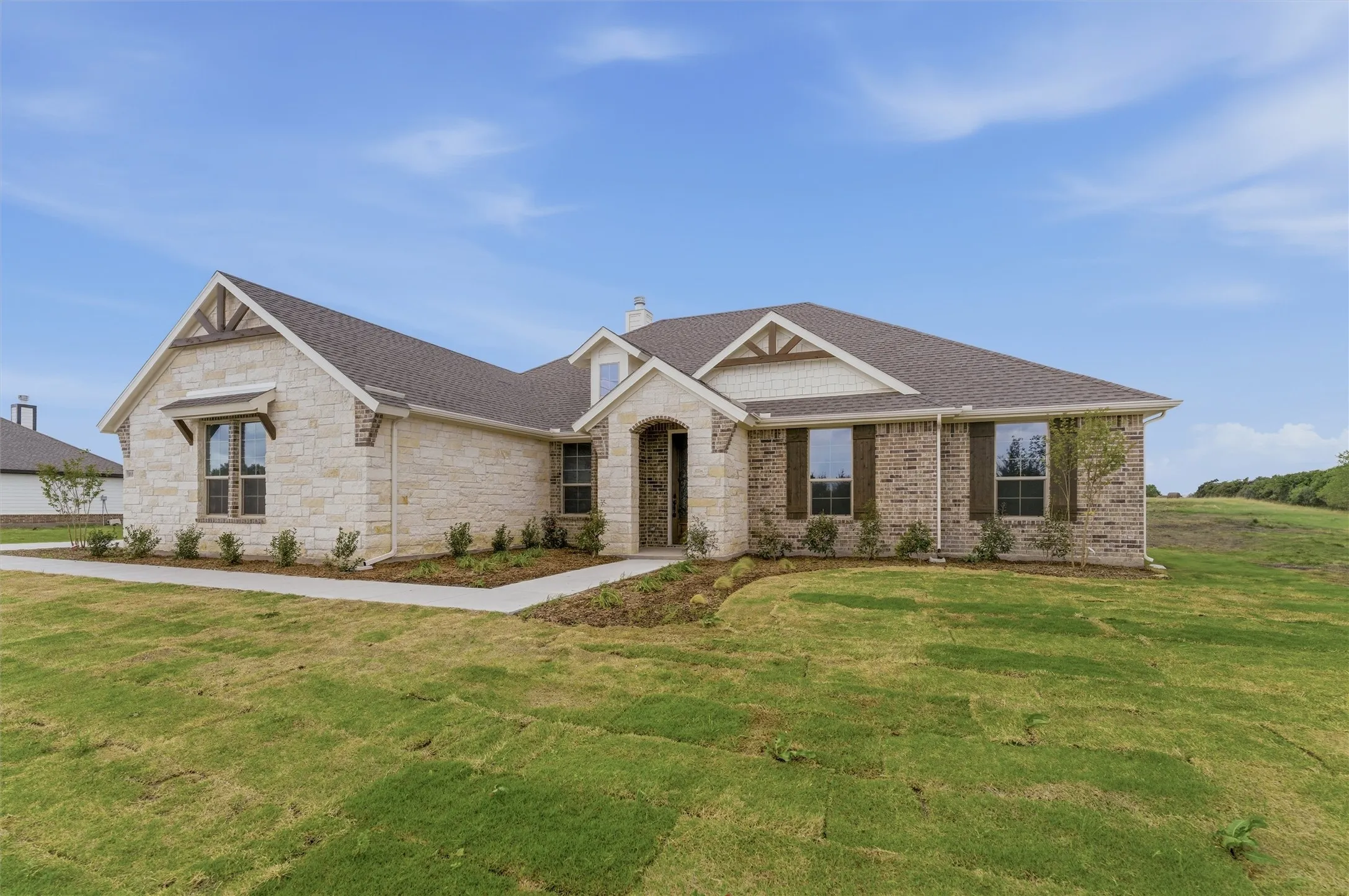 Craftsman inspired home with stone siding, a chimney, roof with shingles, and a front lawn