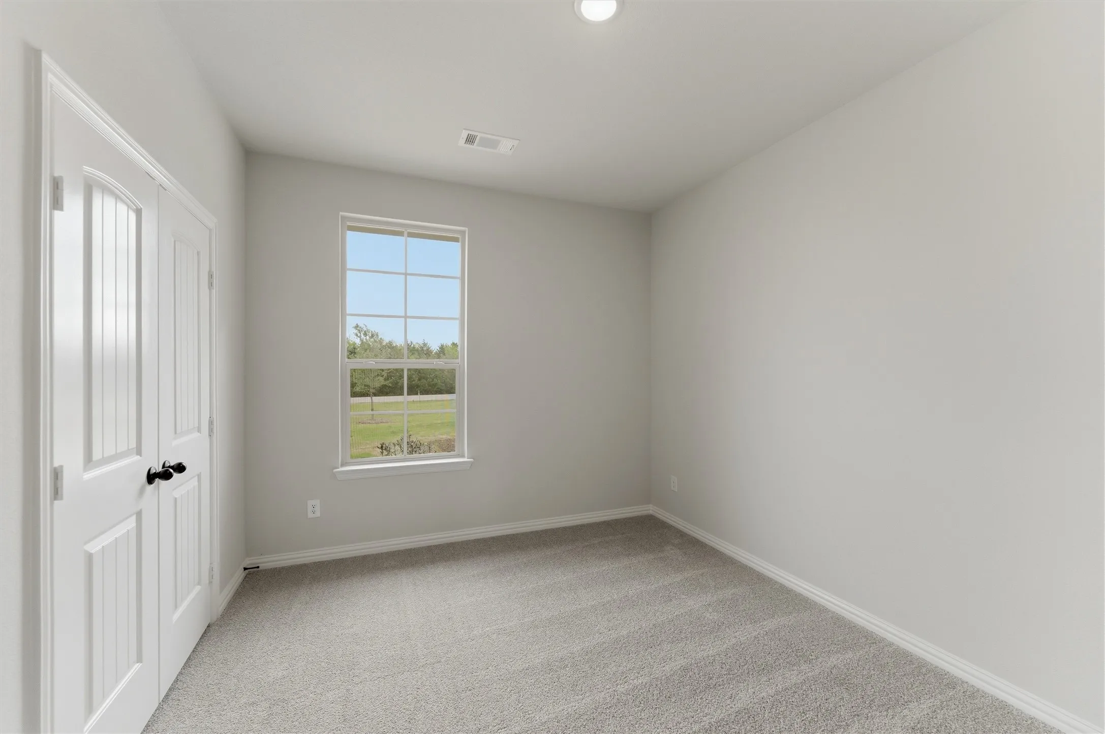 Unfurnished bedroom featuring light carpet and a closet