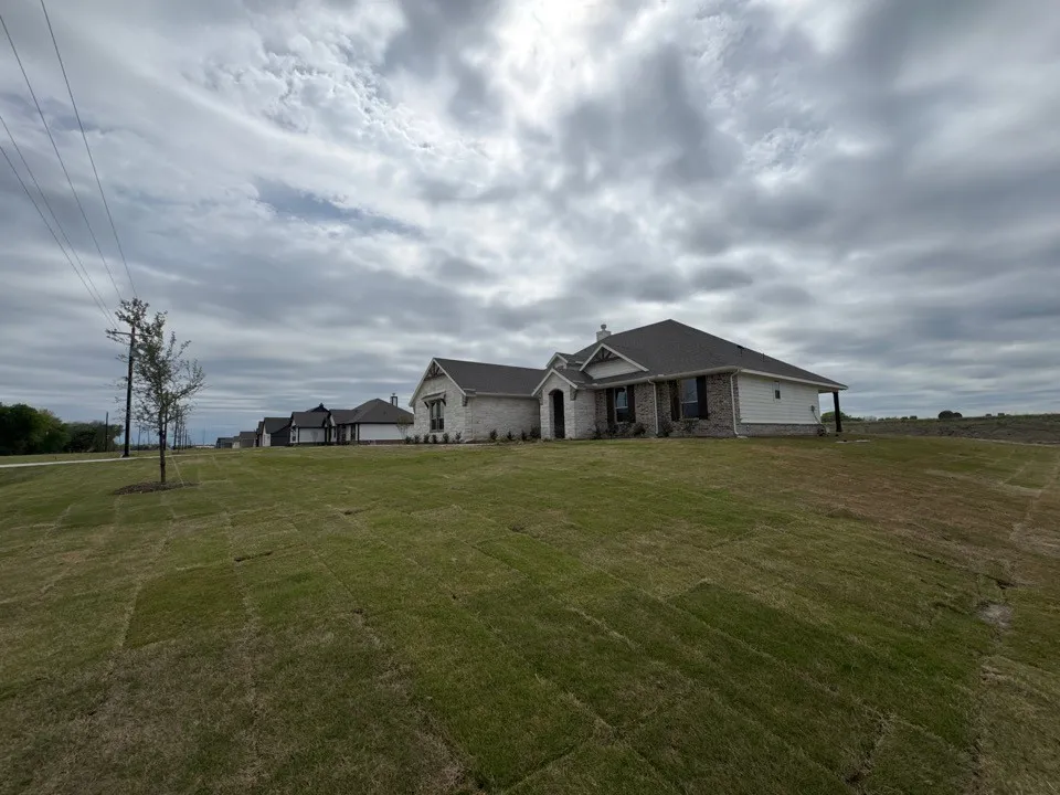 Craftsman inspired home with stone siding, a chimney, roof with shingles, and a front lawn