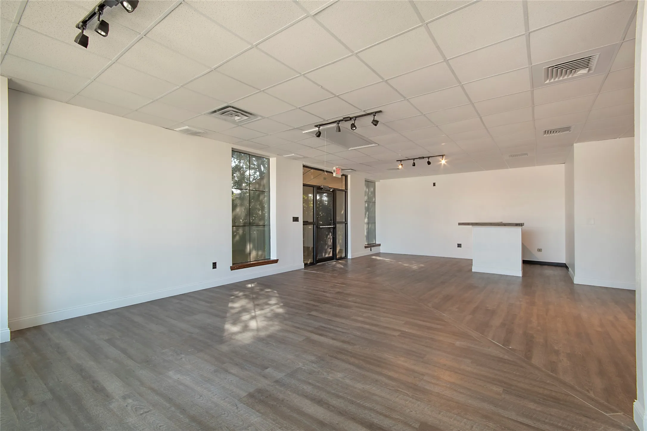 Unfurnished room with rail lighting, dark wood-type flooring, and a paneled ceiling