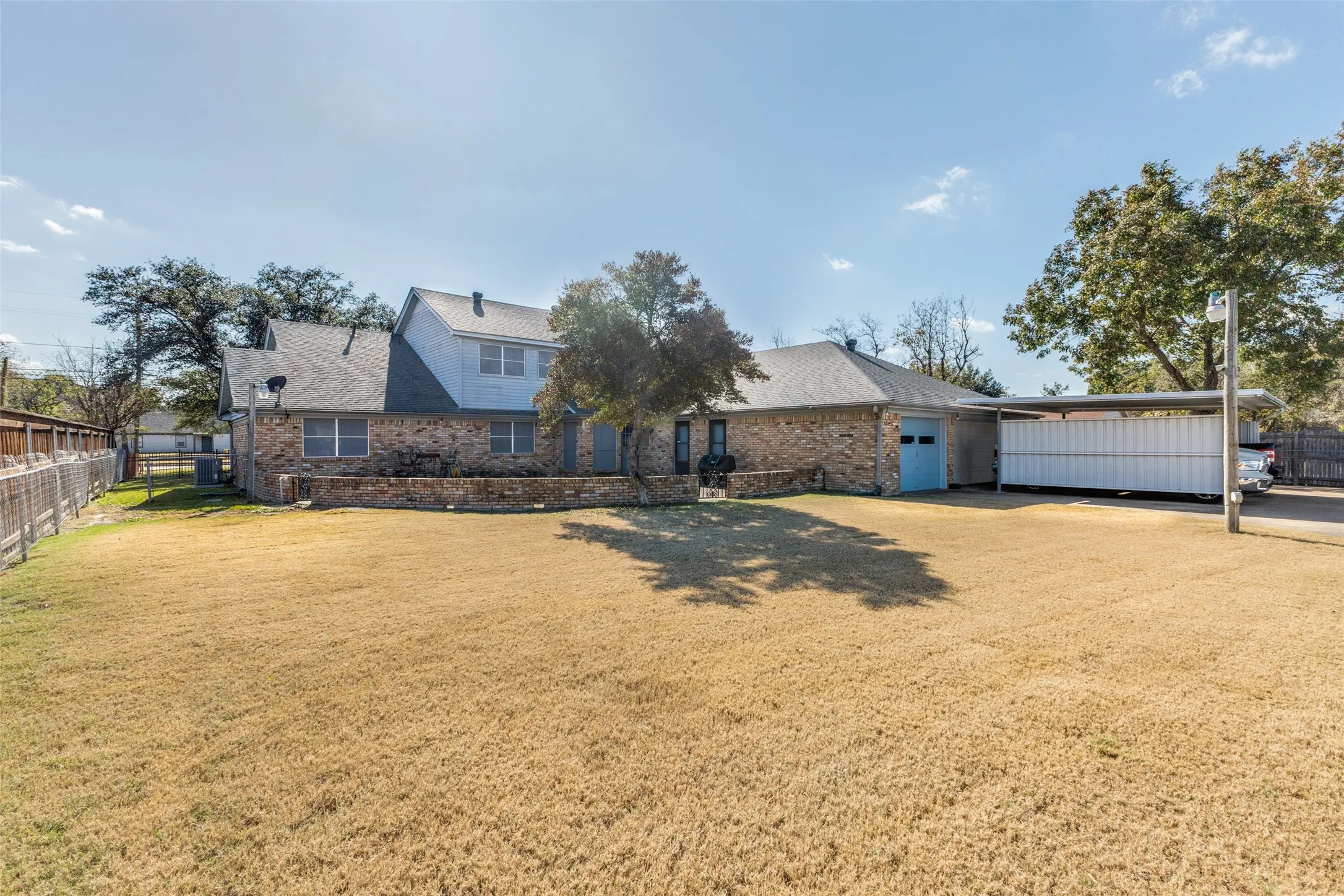 View of front facade featuring roof with shingles, brick siding, and an attached garage