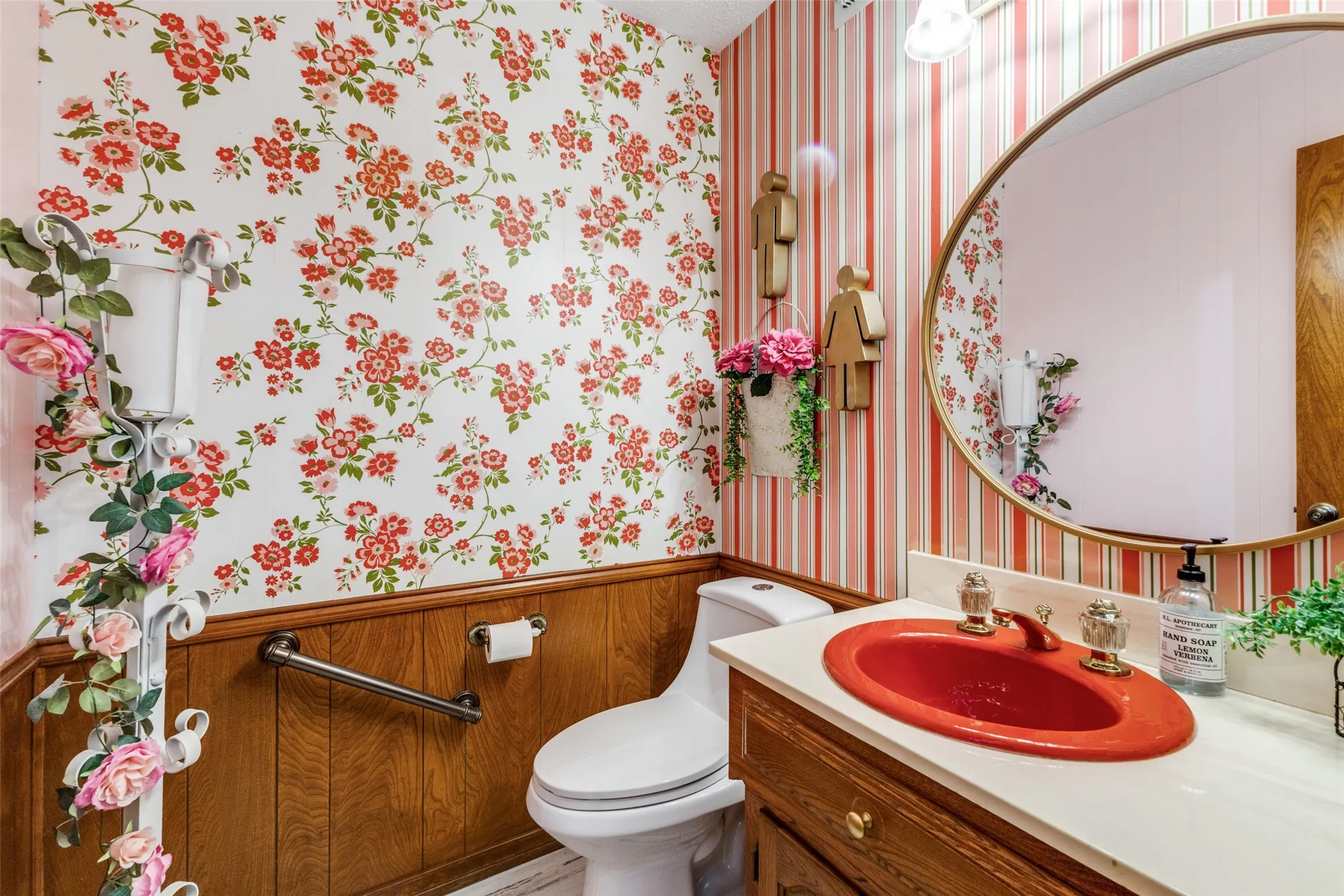 Bathroom with wallpapered walls, vanity, wainscoting, and wooden walls