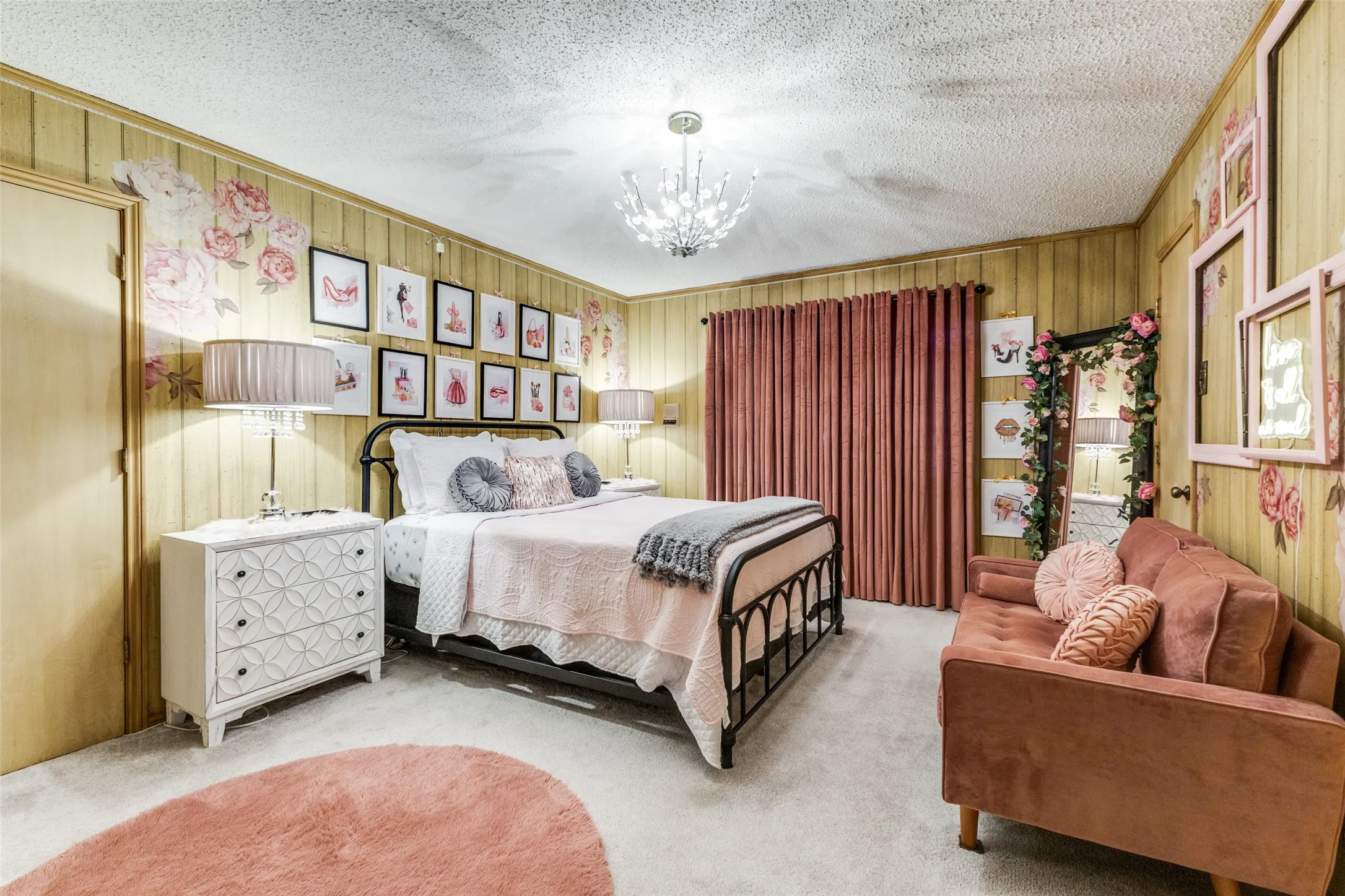 Bedroom with carpet floors, a chandelier, decorator lighting and wood paneled walls.