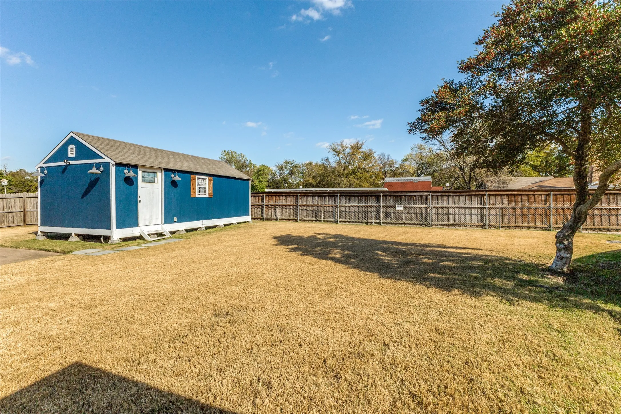 Fenced backyard featuring an outdoor structure