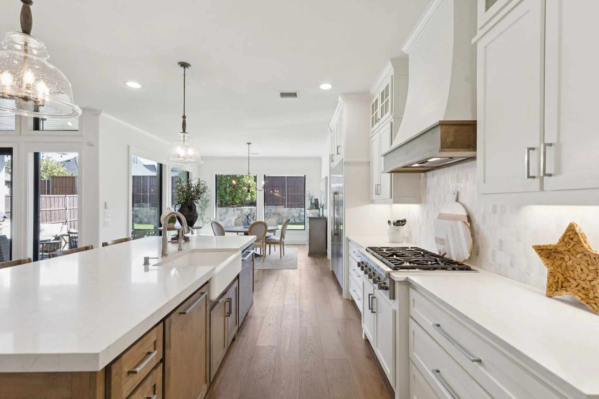 Kitchen featuring white cabinets, hanging light fixtures, a large island, tasteful backsplash, and recessed lighting