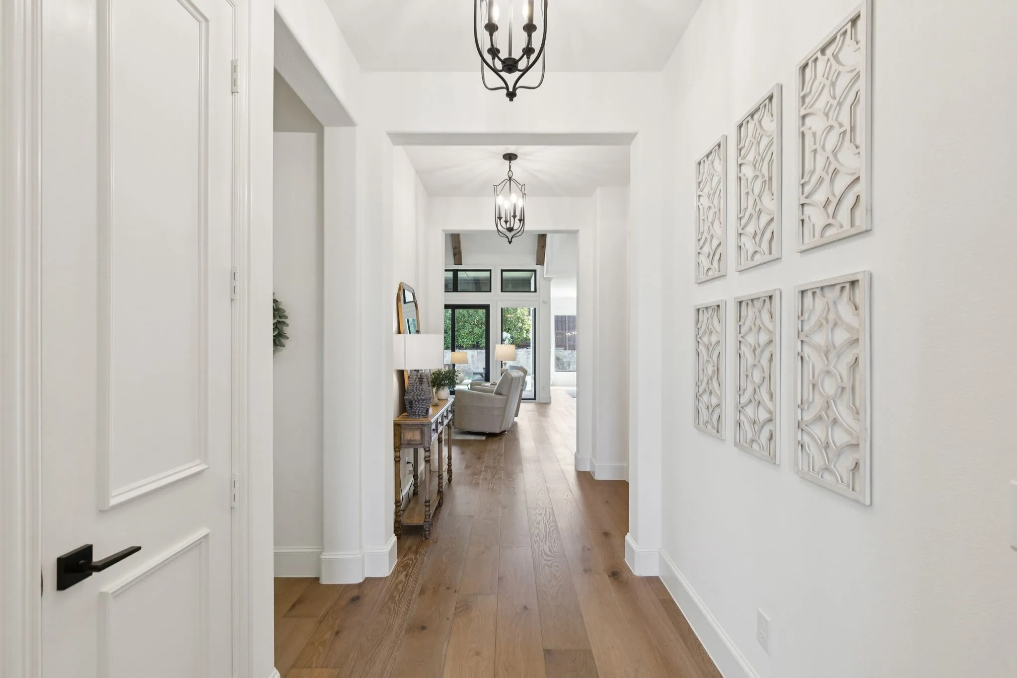 Corridor with hardwood / wood-style floors and a chandelier