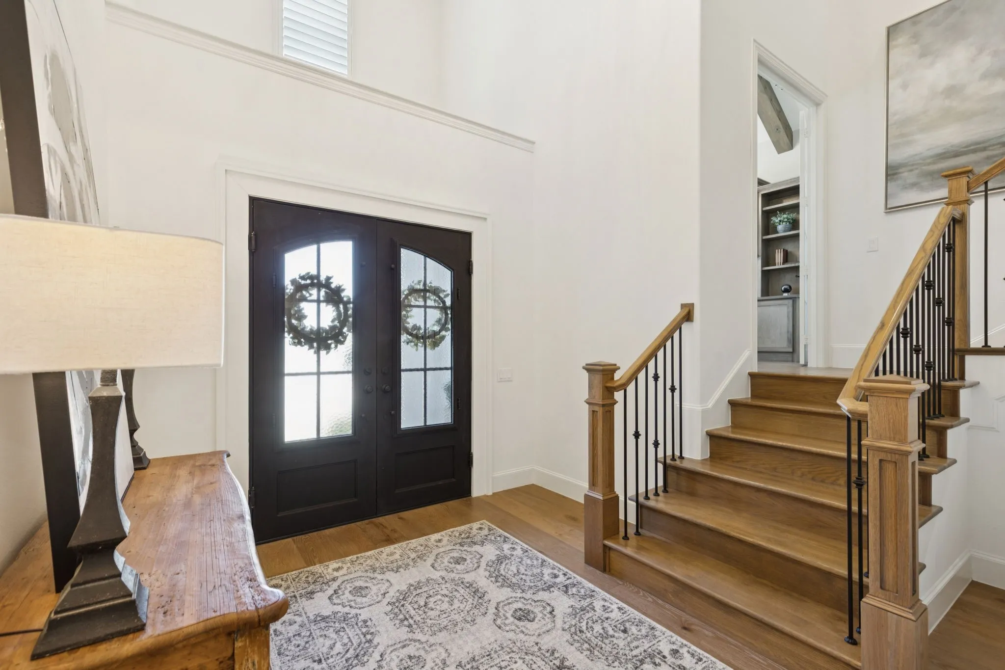 Entrance foyer featuring french doors, healthy amount of natural light, wood finished floors, and stairway