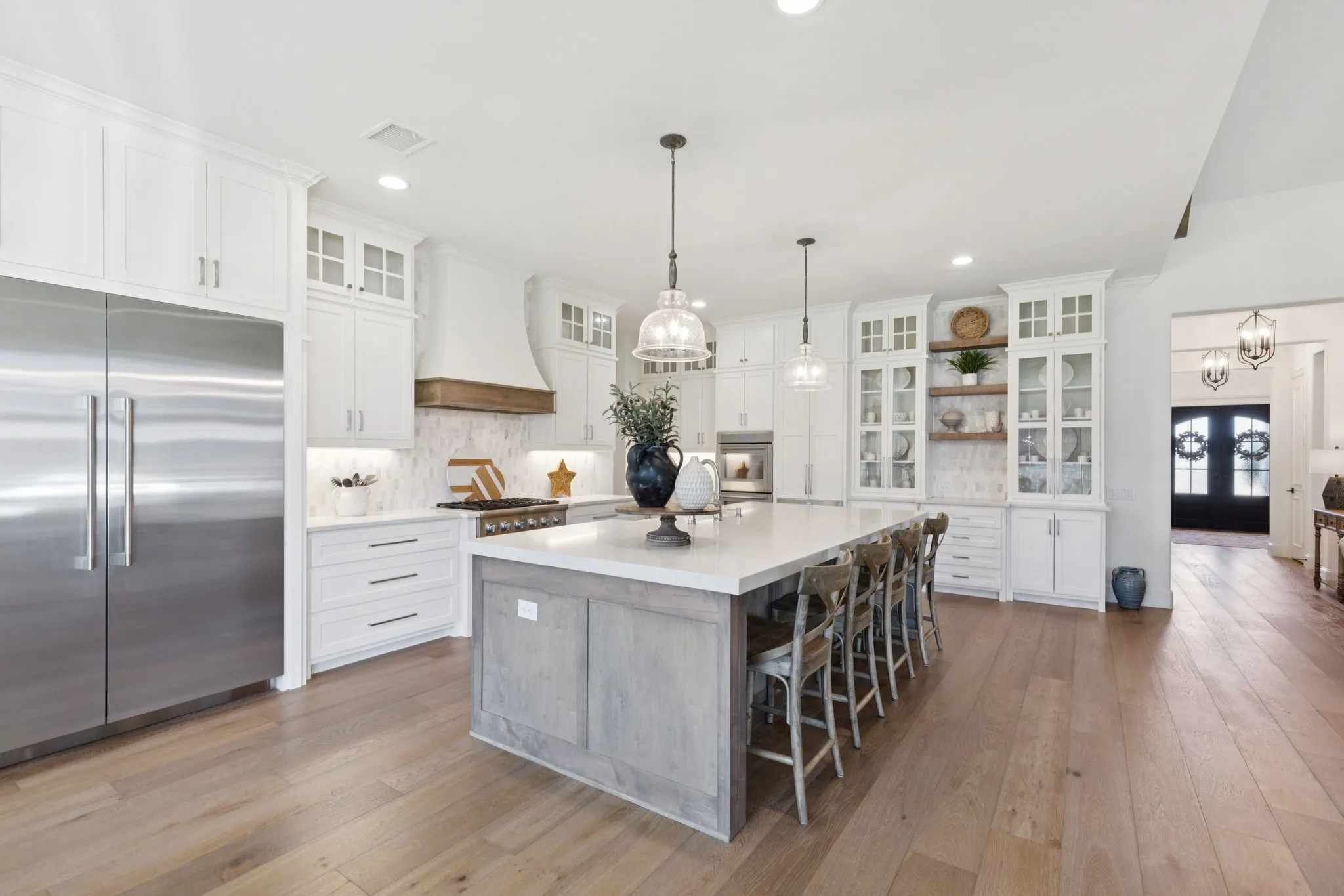 Kitchen with glass insert cabinets, open shelves, appliances with stainless steel finishes, white cabinets, and recessed lighting