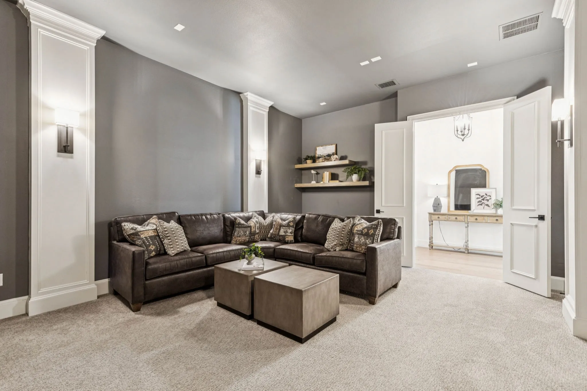 Living area with light colored carpet and decorative columns