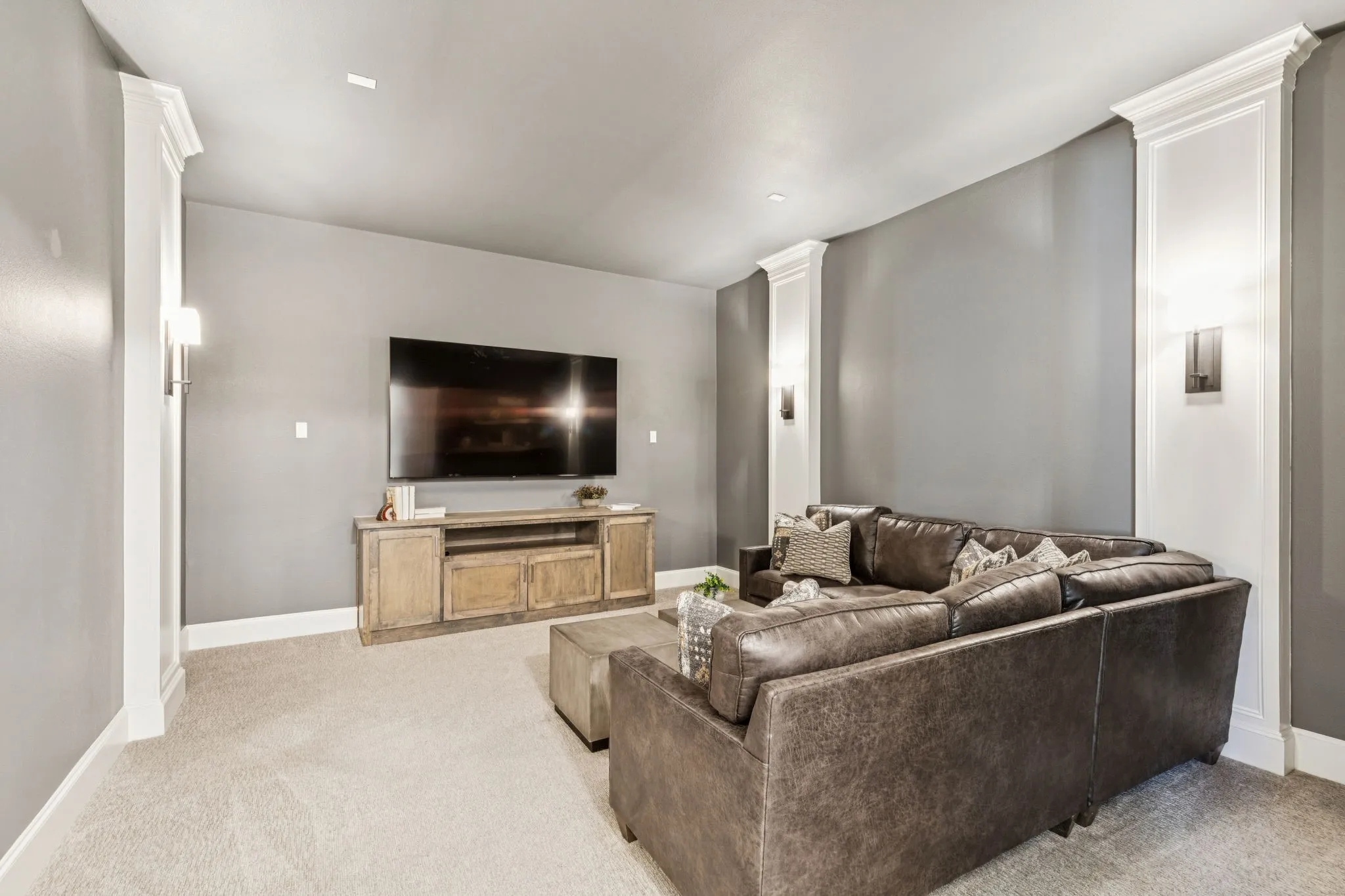 Living area with light colored carpet and decorative columns