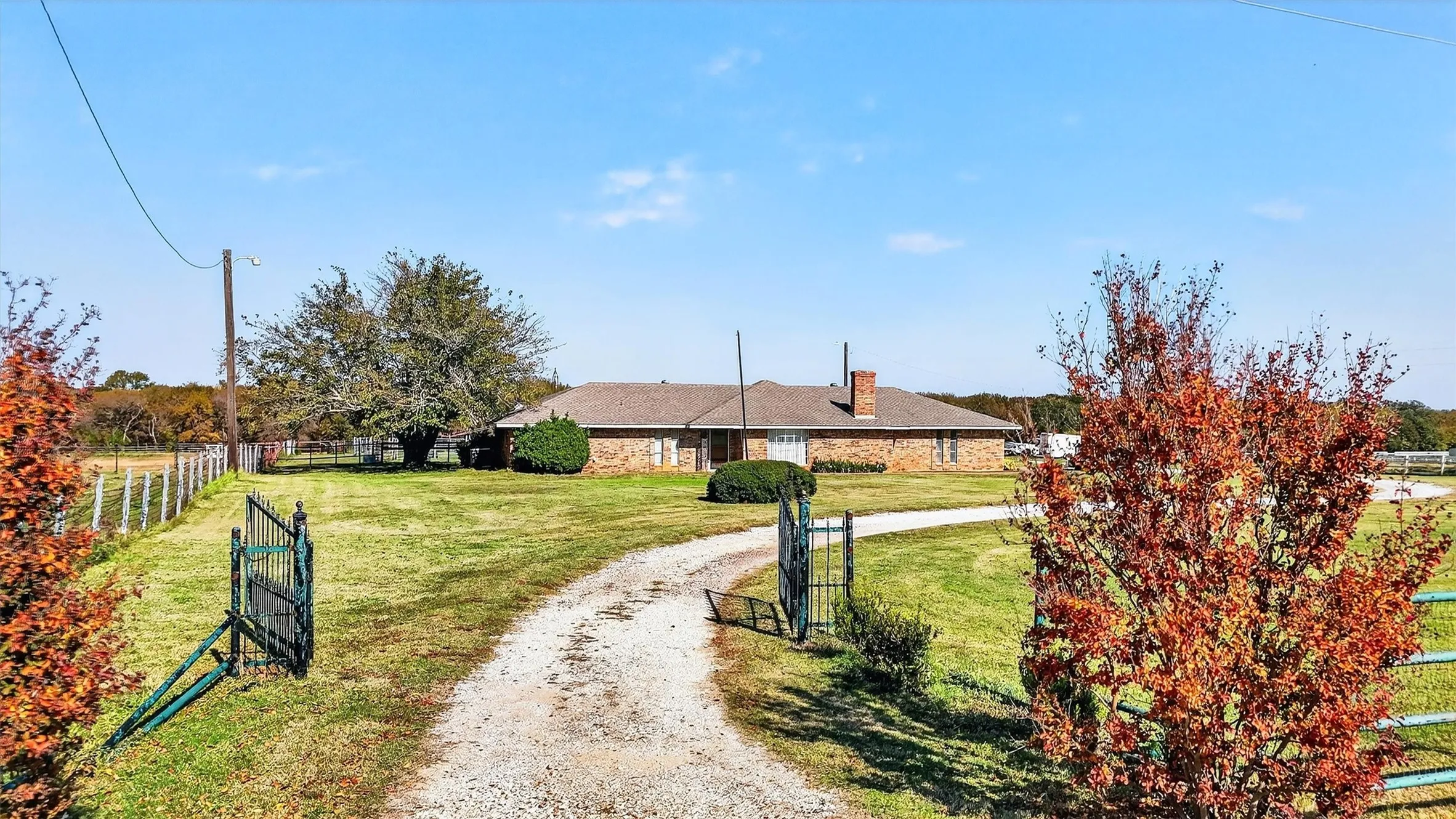 Single story home featuring a chimney and driveway