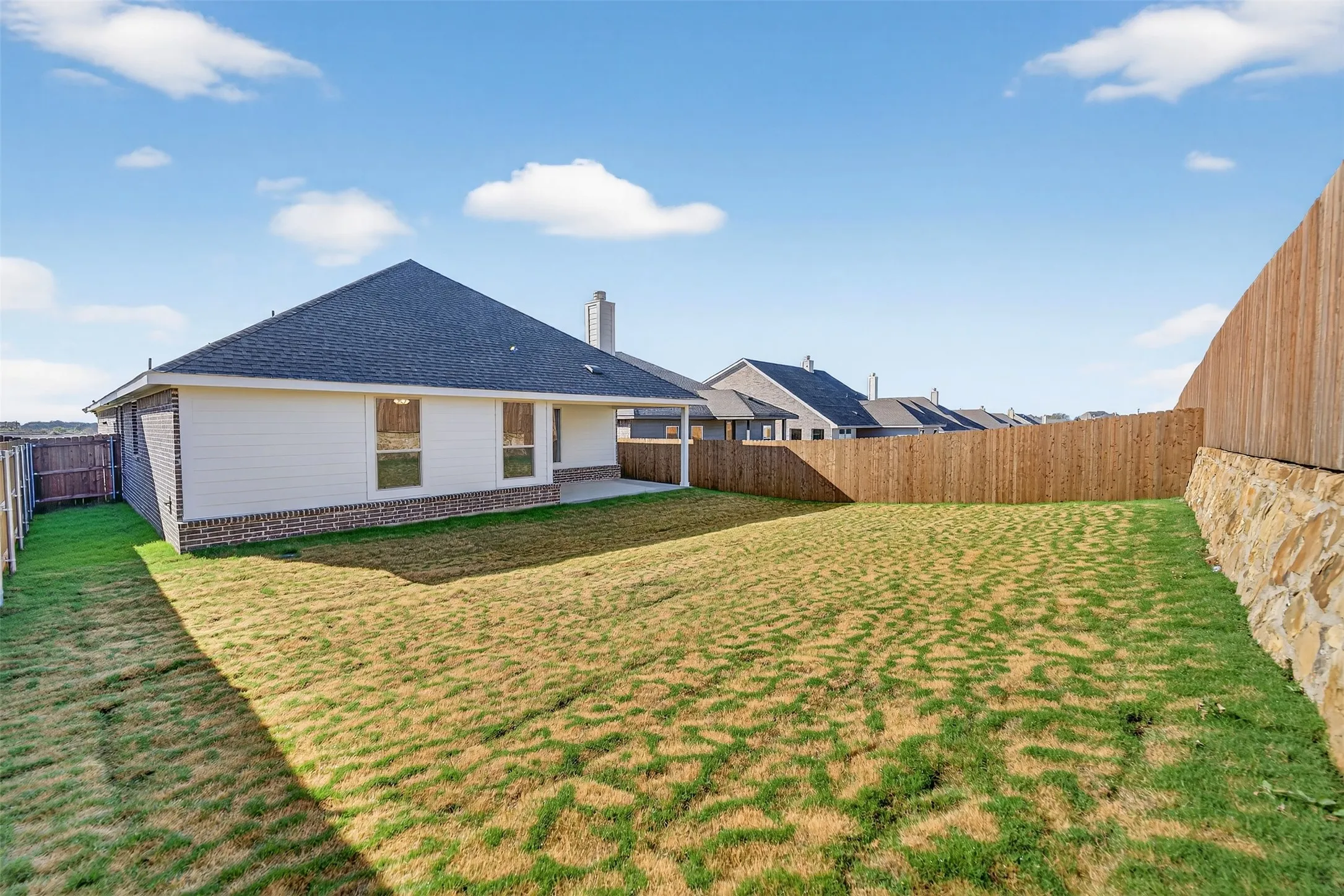 Rear view of property featuring a fenced backyard, a patio, a chimney, and a shingled roof