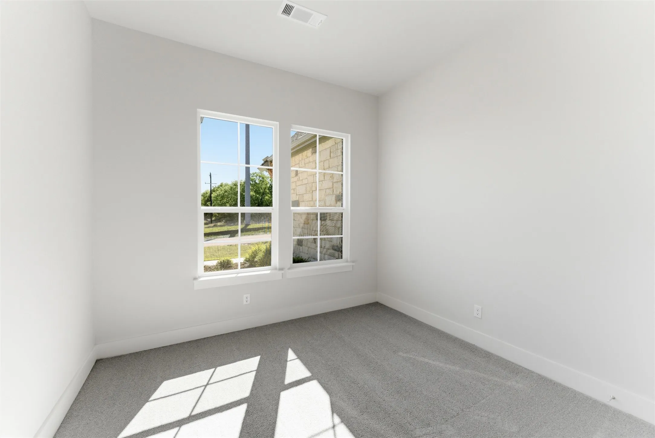 Spare room with light colored carpet and baseboards