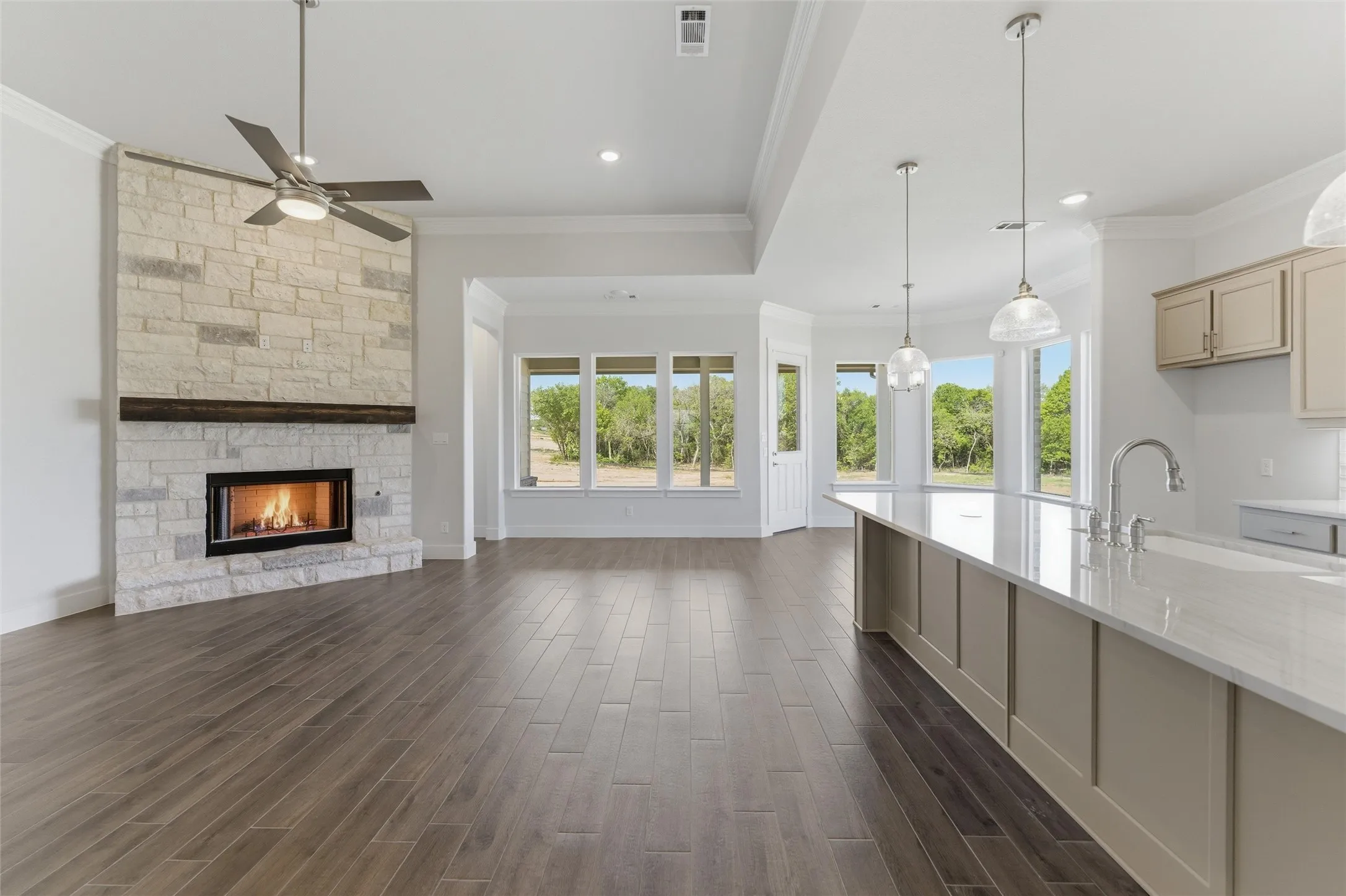 Unfurnished living room featuring a fireplace, dark wood-style floors, crown molding, ceiling fan, and recessed lighting