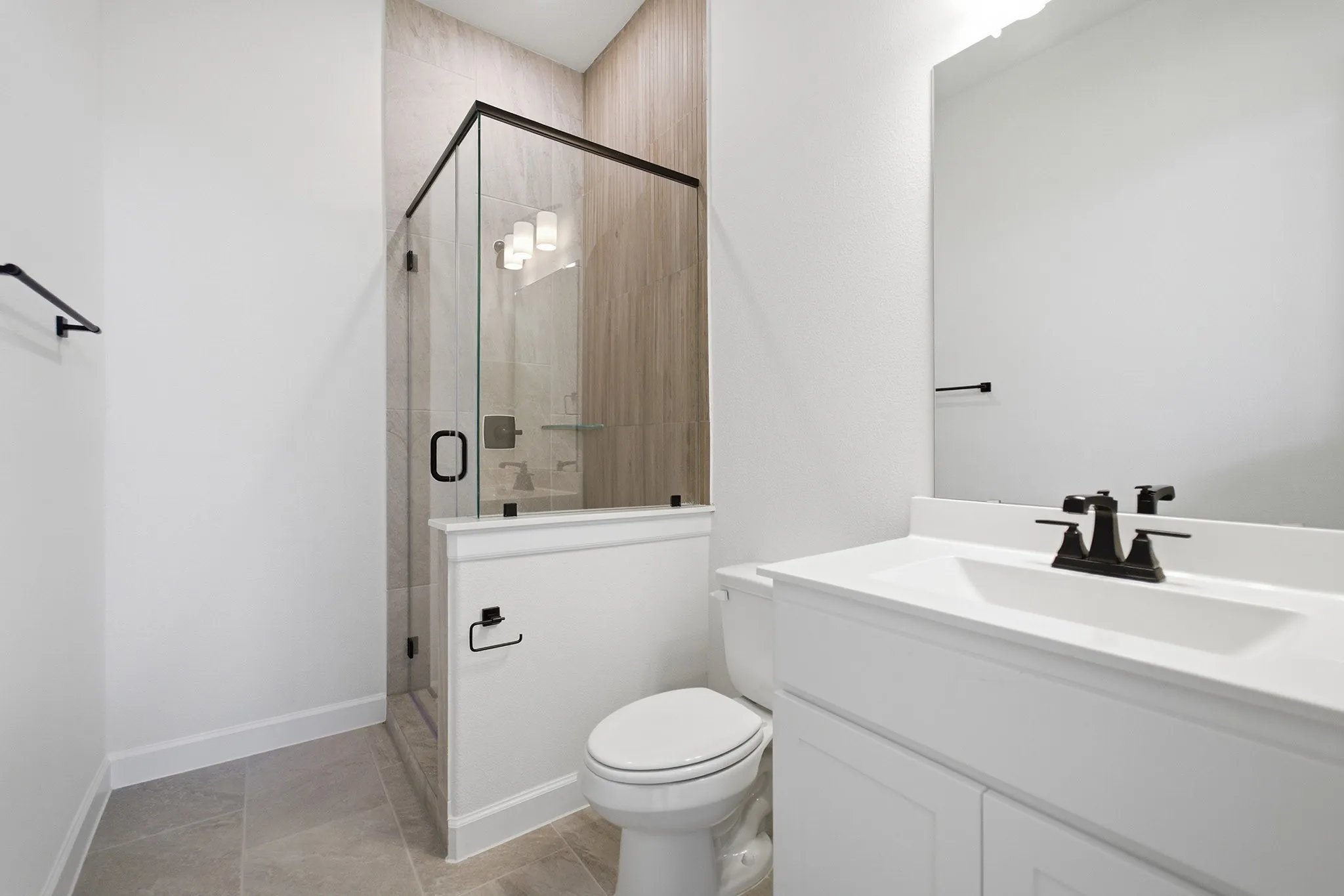 Contemporary bathroom featuring a glass-enclosed shower with tiled walls and a built-in shelf