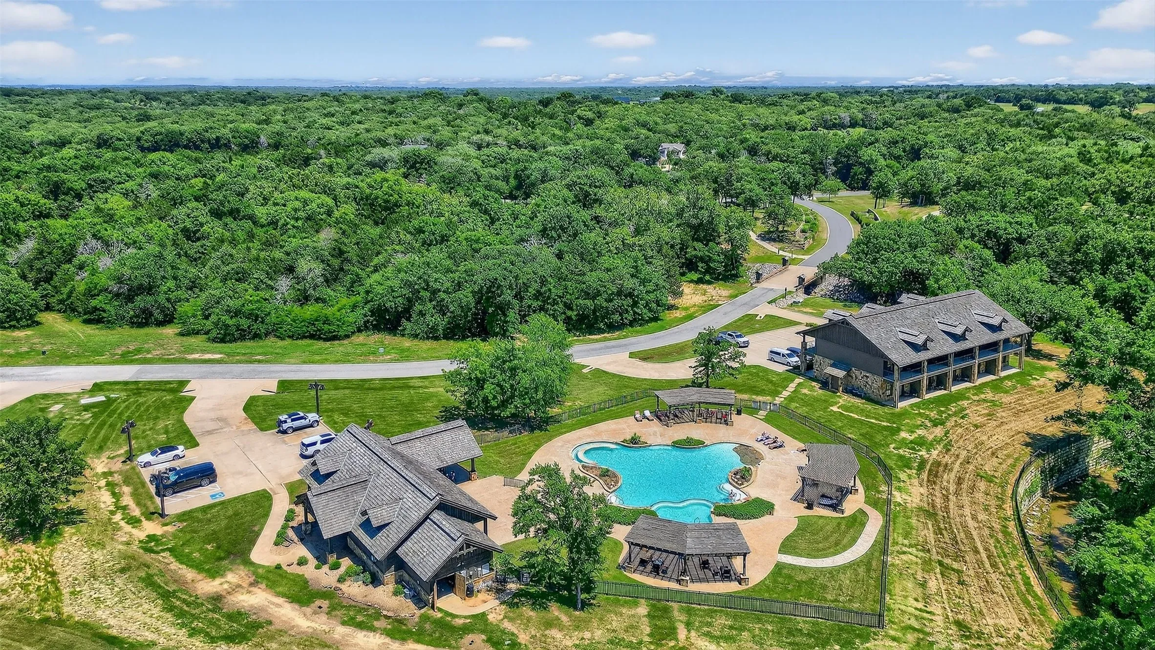 Bird's eye view of a pool and a heavily wooded area