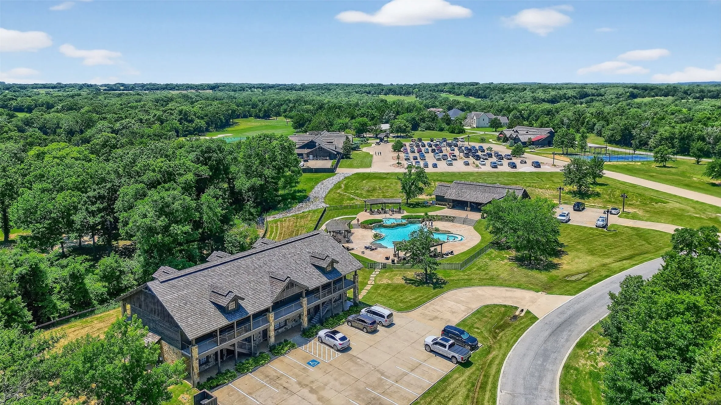 Drone / aerial view of a pool area and a forest