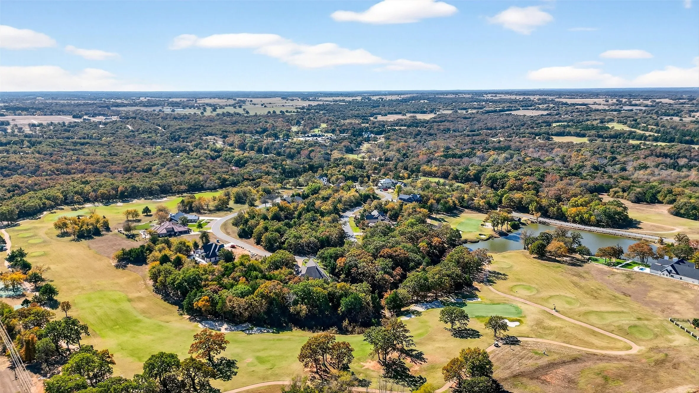 Bird's eye view of a golf course and a nearby body of water