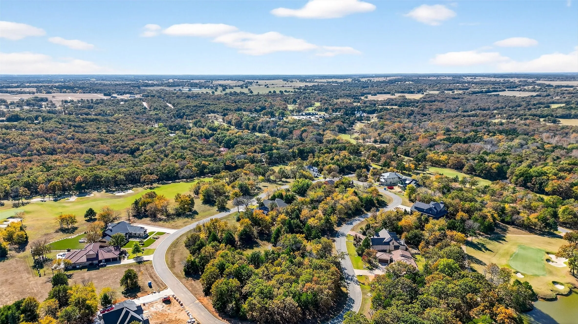Bird's eye view of a golf course and a tree filled landscape