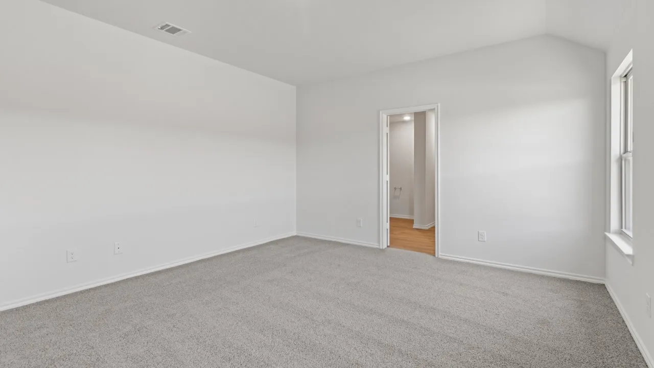 Unfurnished room with light carpet and lofted ceiling