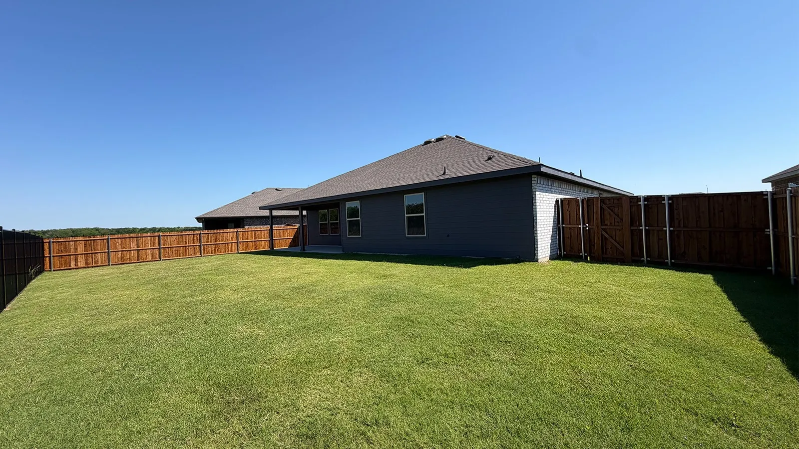 Expansive grass backyard with wood privacy fencing