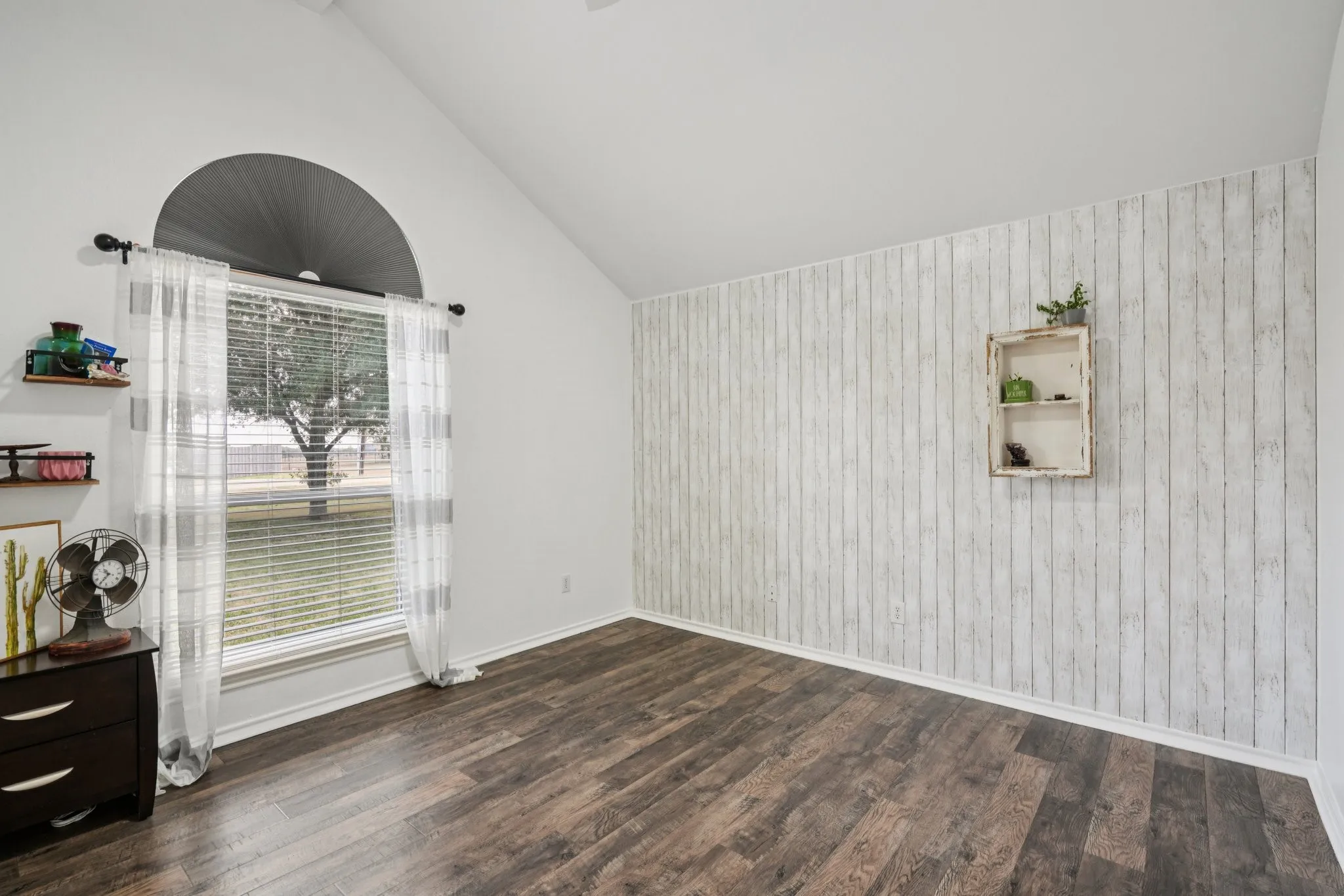 Spare room featuring LVP floors, vaulted ceiling