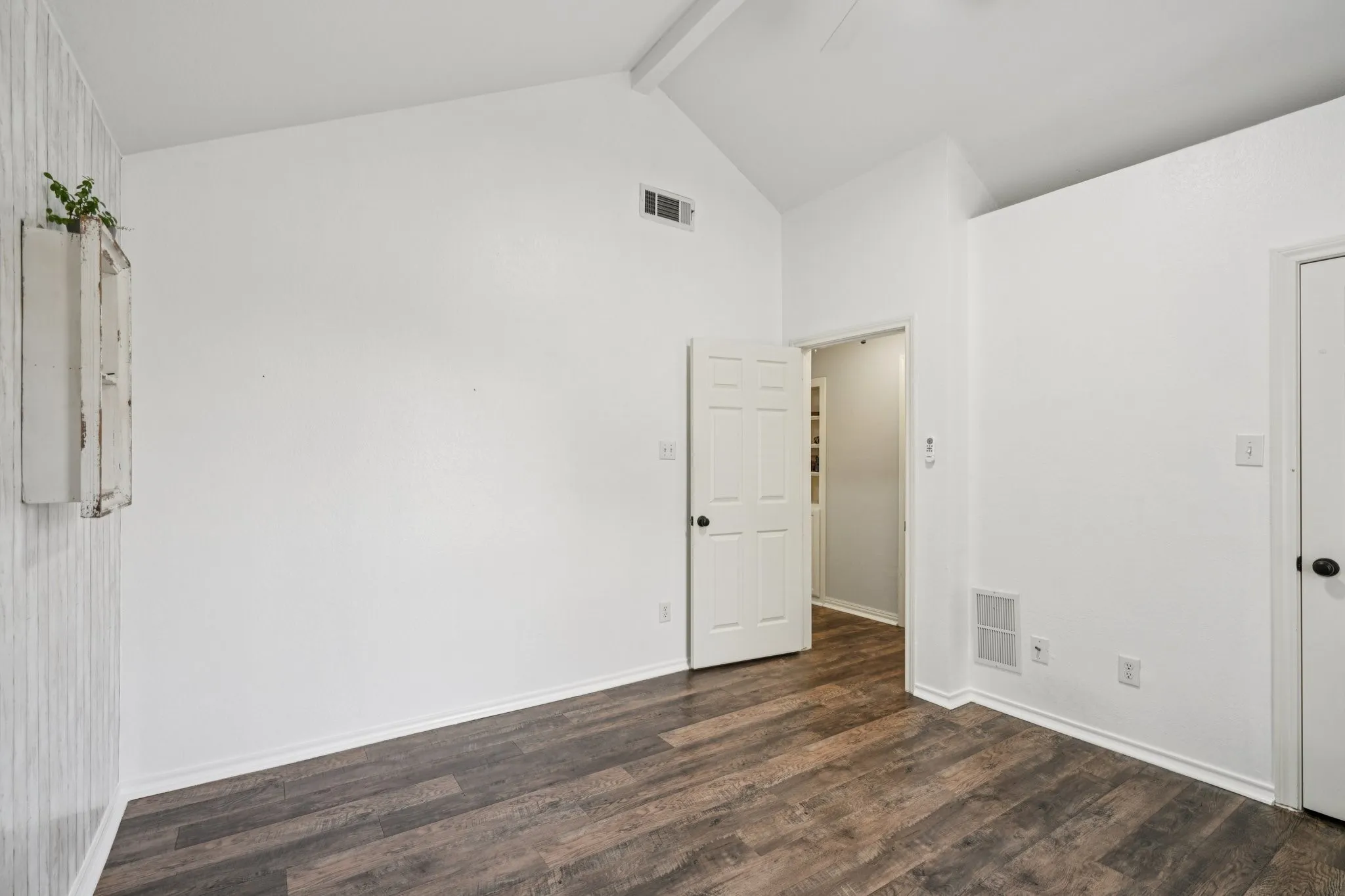 Spare room featuring LVP floors, beam ceiling, and high vaulted ceiling