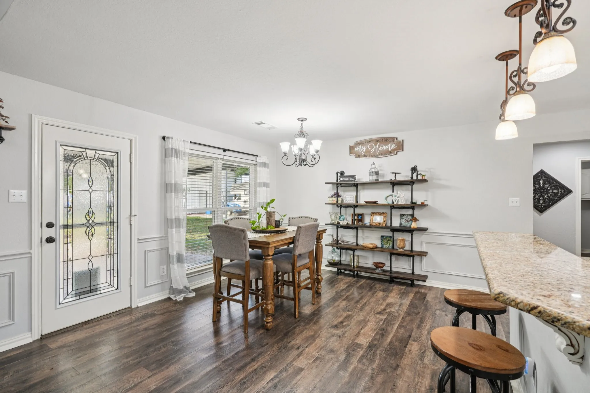 Dining area featuring wainscoting, LVP Flooring, a decorative wall, and a chandelier